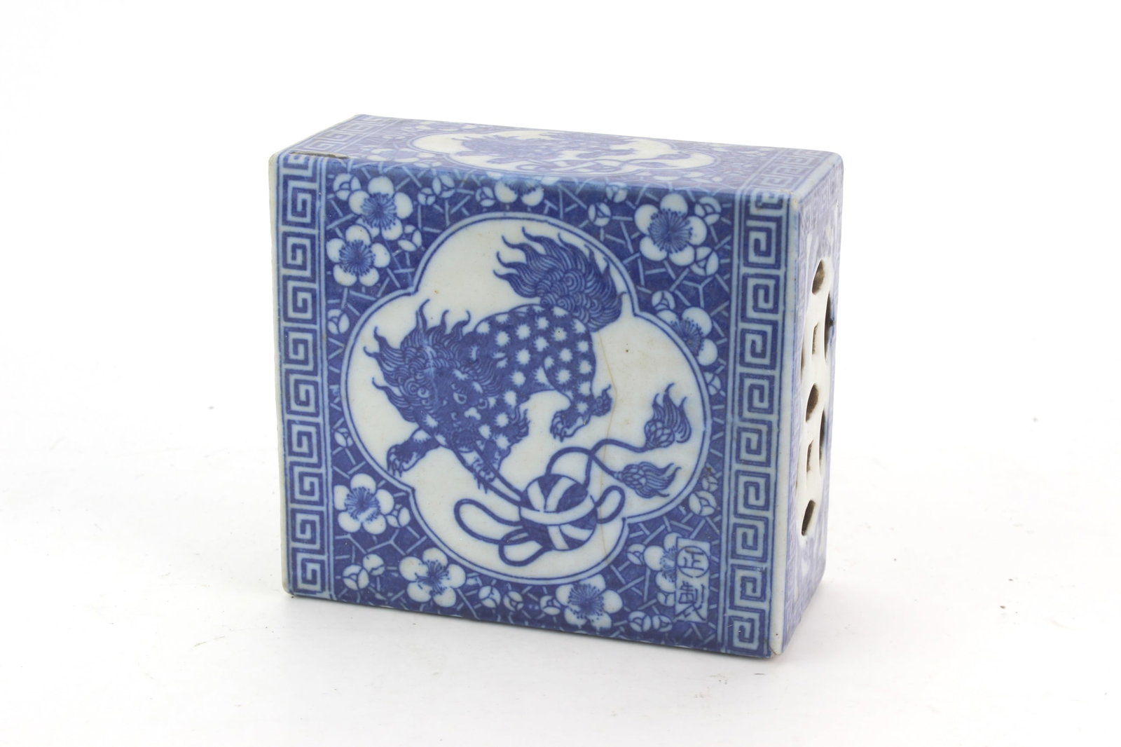 Chinese Blue & White Porcelain Block: Chinese blue and white rectangular porcelain block decorated with mythical beast motifs, floral designs and geometric key-fret borders. Pierced openings on the sides and an open underside. Measures 5