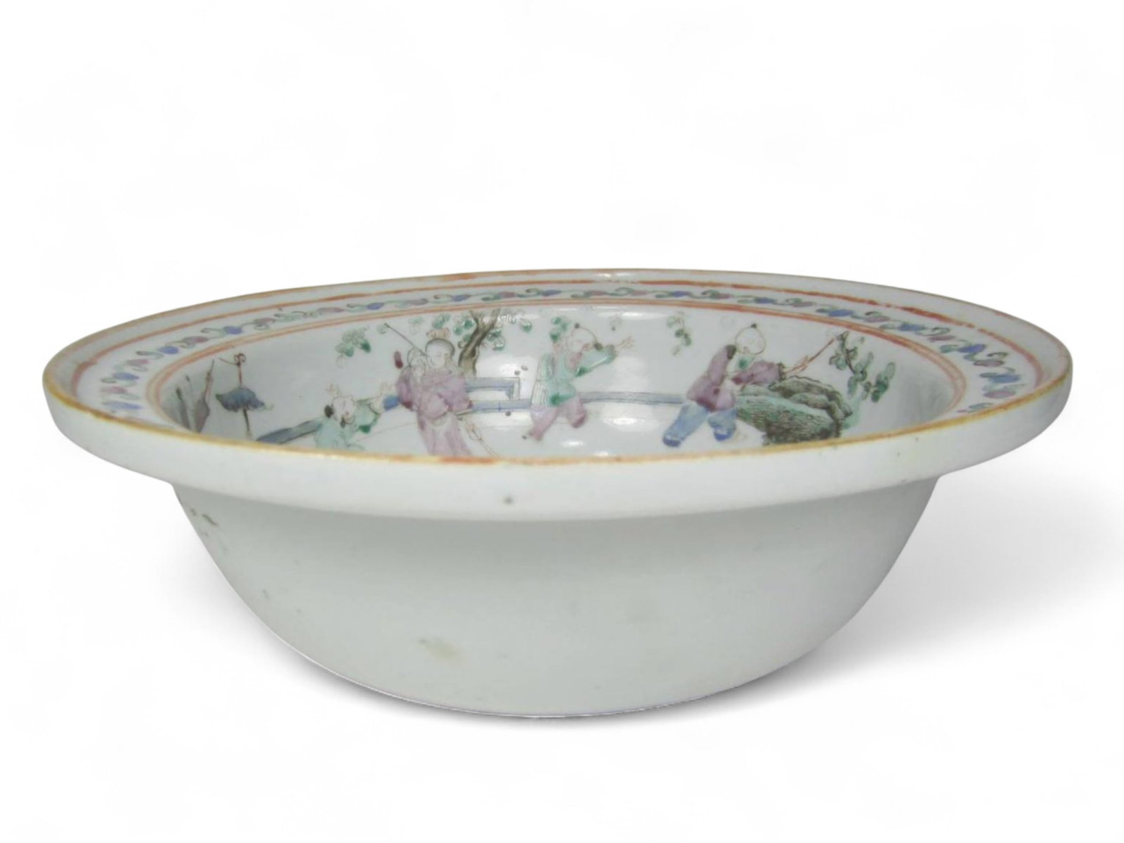 Chinese Famille Rose Figural Porcelain Basin: Chinese porcelain basin decorated in famille rose enamels with figures and children in a garden, framed by floral scroll borders. Unglazed base with old label. Shows age wear, glaze lines, and minor