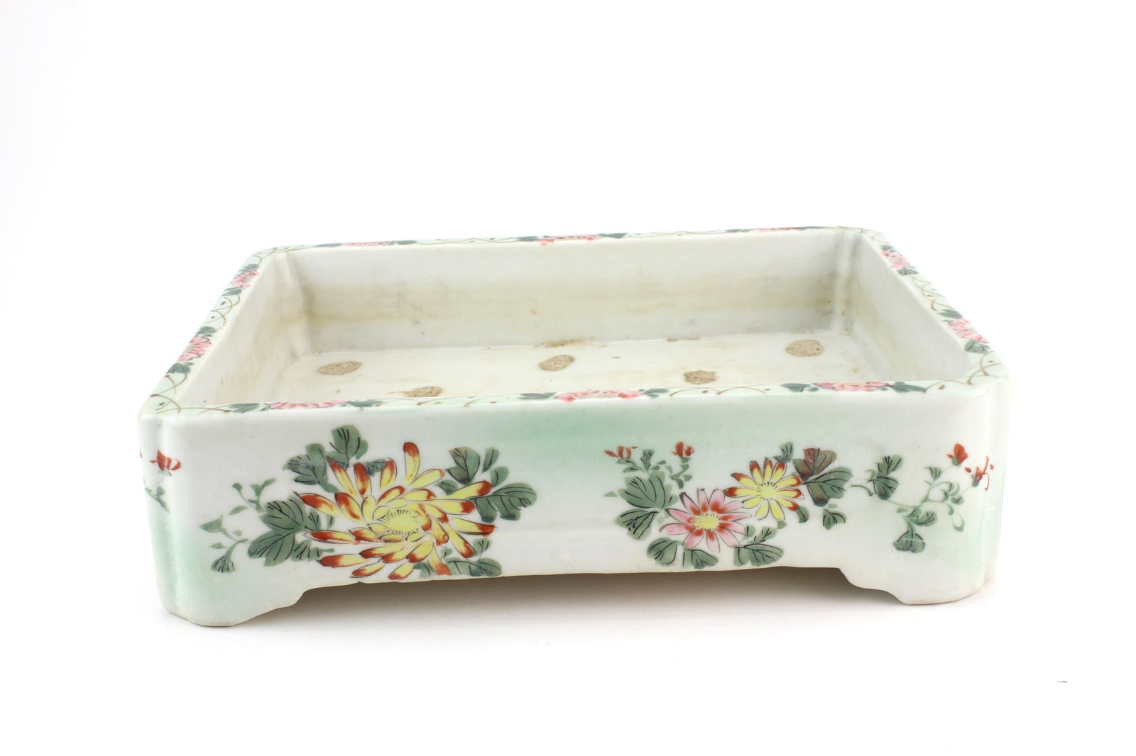 Chinese Famille Rose Ceramic Planter: Chinese famille rose rectangular ceramic planter with hand-painted floral decoration and raised corner feet. Measures approximately 8 in. (W) X 11 in. (L) X 3 in. (H). Shows age-related wear, light