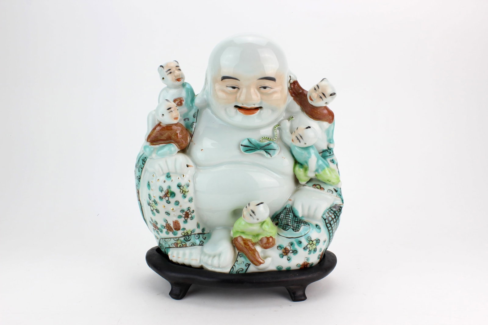 Famille Rose Buddha w/ Children: Chinese famille rose porcelain figure of a Laughing Buddha surrounded by five children, accompanied by a fitted wood stand. Marked on the bottom. Measures approximately 10 3/4 in. (H) X 9 in. (L) X 5