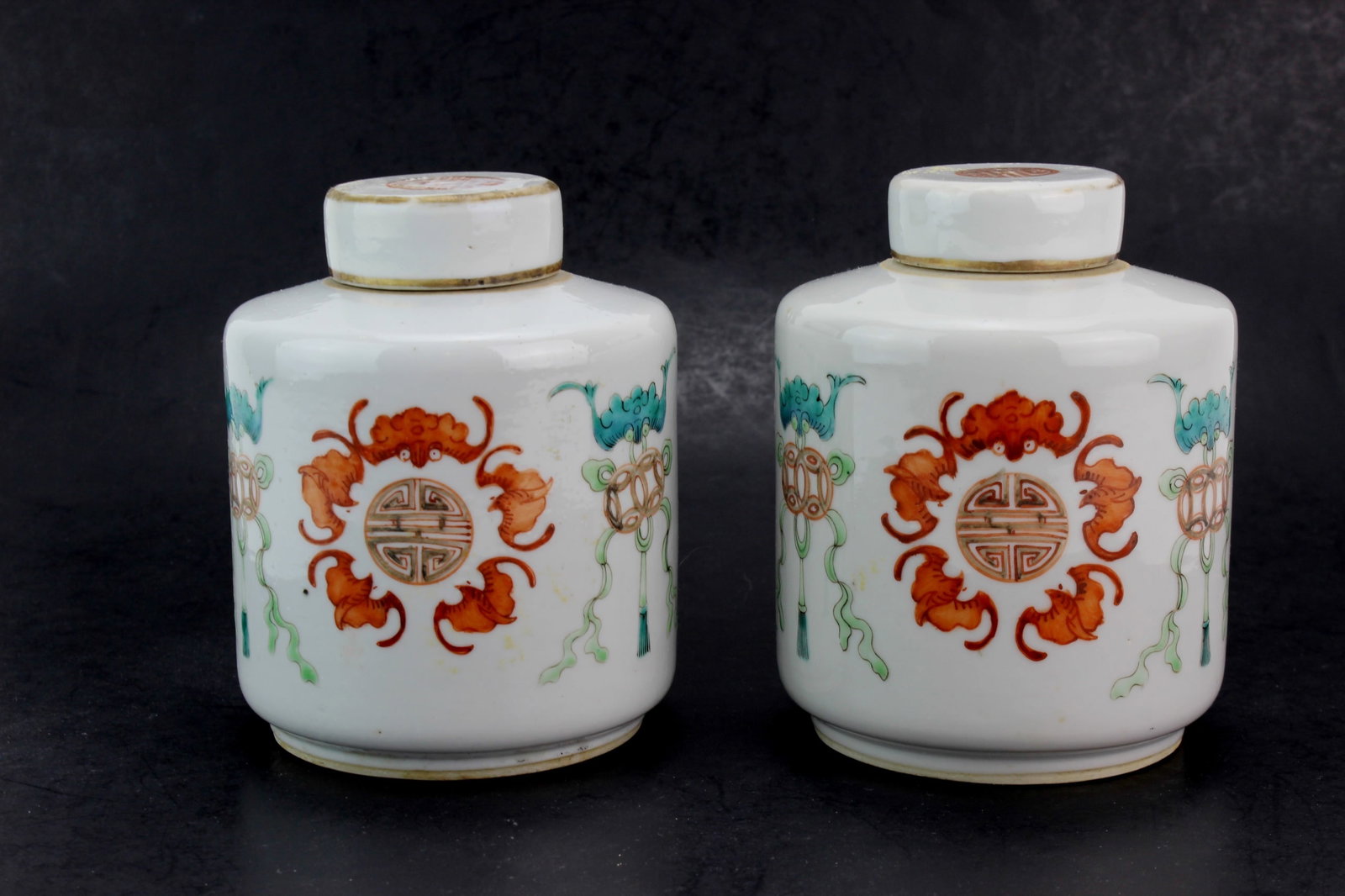 Pair Chinese Famille Verte Tea Caddies: Pair of Chinese famille verte porcelain lidded tea caddies with longevity medallion and auspicious motif decoration. Each measures approximately 5 in. (H) X 4 in. (D). Overall good condition with