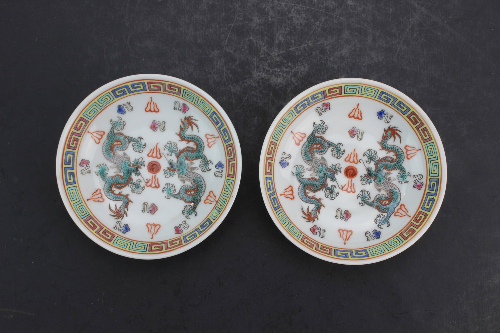 Pair Chinese Porcelain Dragon Dishes: Pair of Chinese porcelain small dishes decorated with colorful dragon motifs and geometric border designs. Marked ?Made in China? on underside. Each measures 3 3/4 in. (D) x 1 in. (H). Good overall