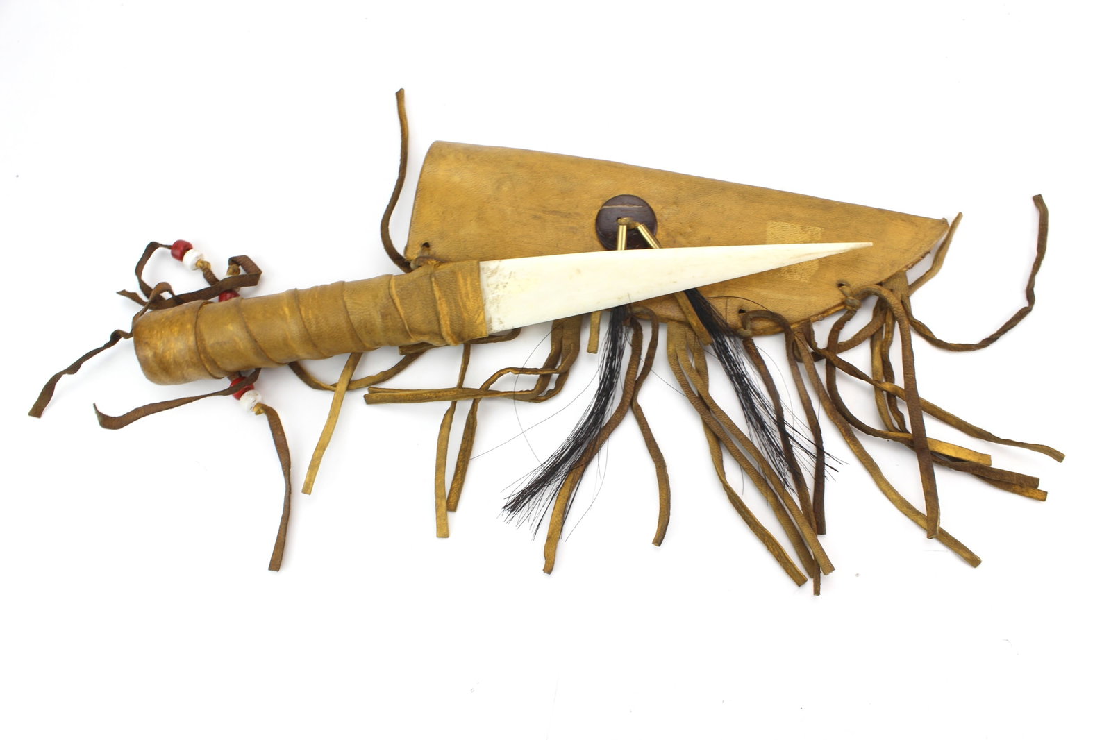 Navajo Style Bone Knife w/ Leather Sheath: Navajo style bone knife with leather wrapped handle and handmade leather sheath decorated with fringe, beads, and horsehair accents. Measures 12 in. (L). Overall good vintage condition with wear,