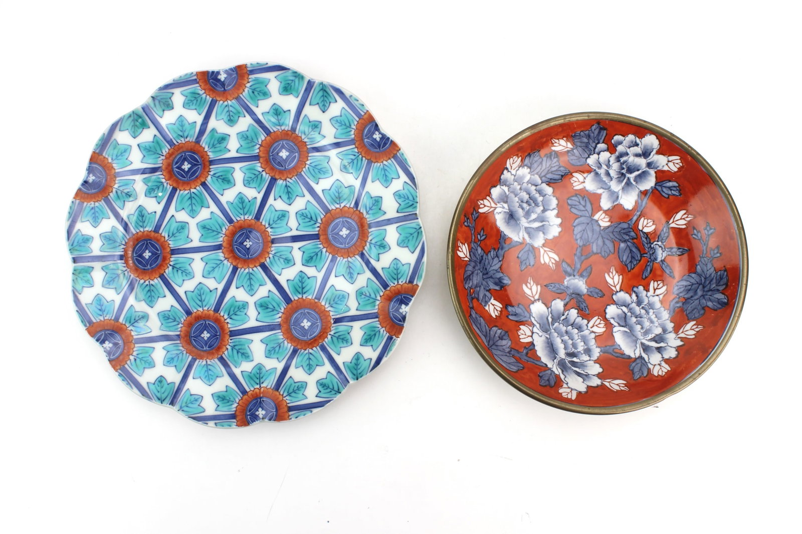 Pair of Asian Porcelain Plates: Pair of Asian porcelain decorative plates featuring colorful floral and geometric motifs. One plate marked on underside. Measures 9 1/2 in. and 7 1/2 in. diam. respectively. Minor surface wear and