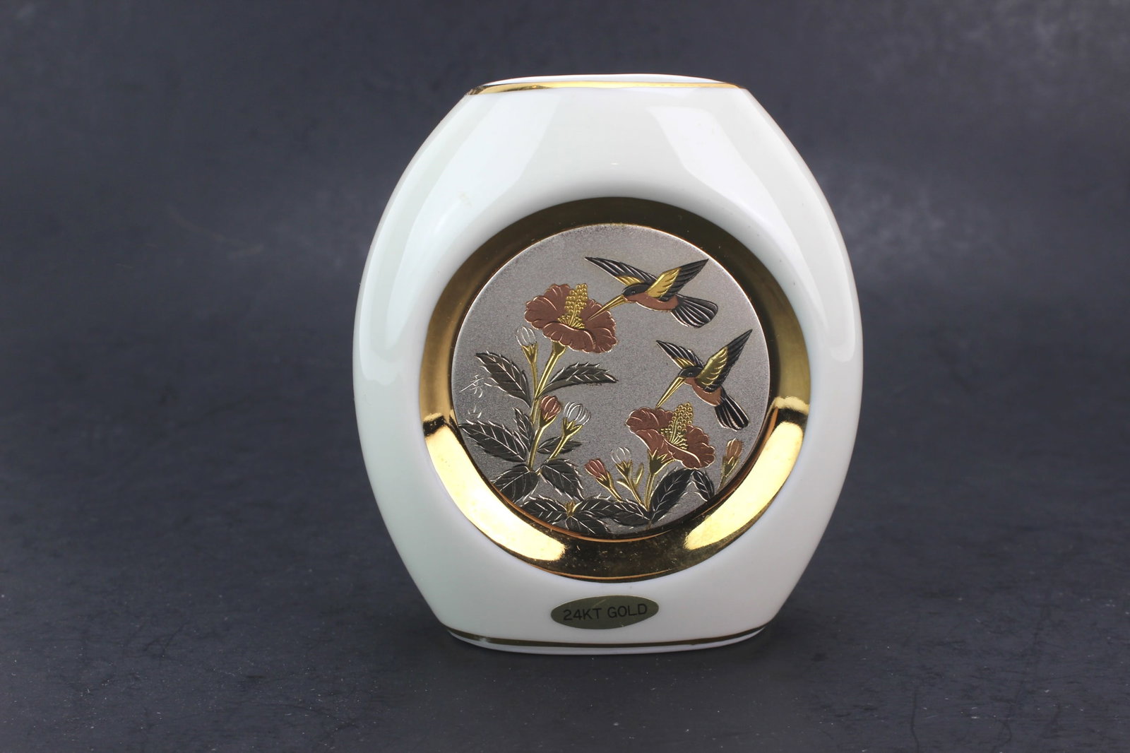 Japanese Chokin Porcelain Vase: Japanese porcelain vase featuring Chokin-style hummingbird and floral decoration with 24KT gold accents. Measures 3 1/2 in. (L) X 3 1/2 in. (H) X 2 in. (W). In good overall condition with minor