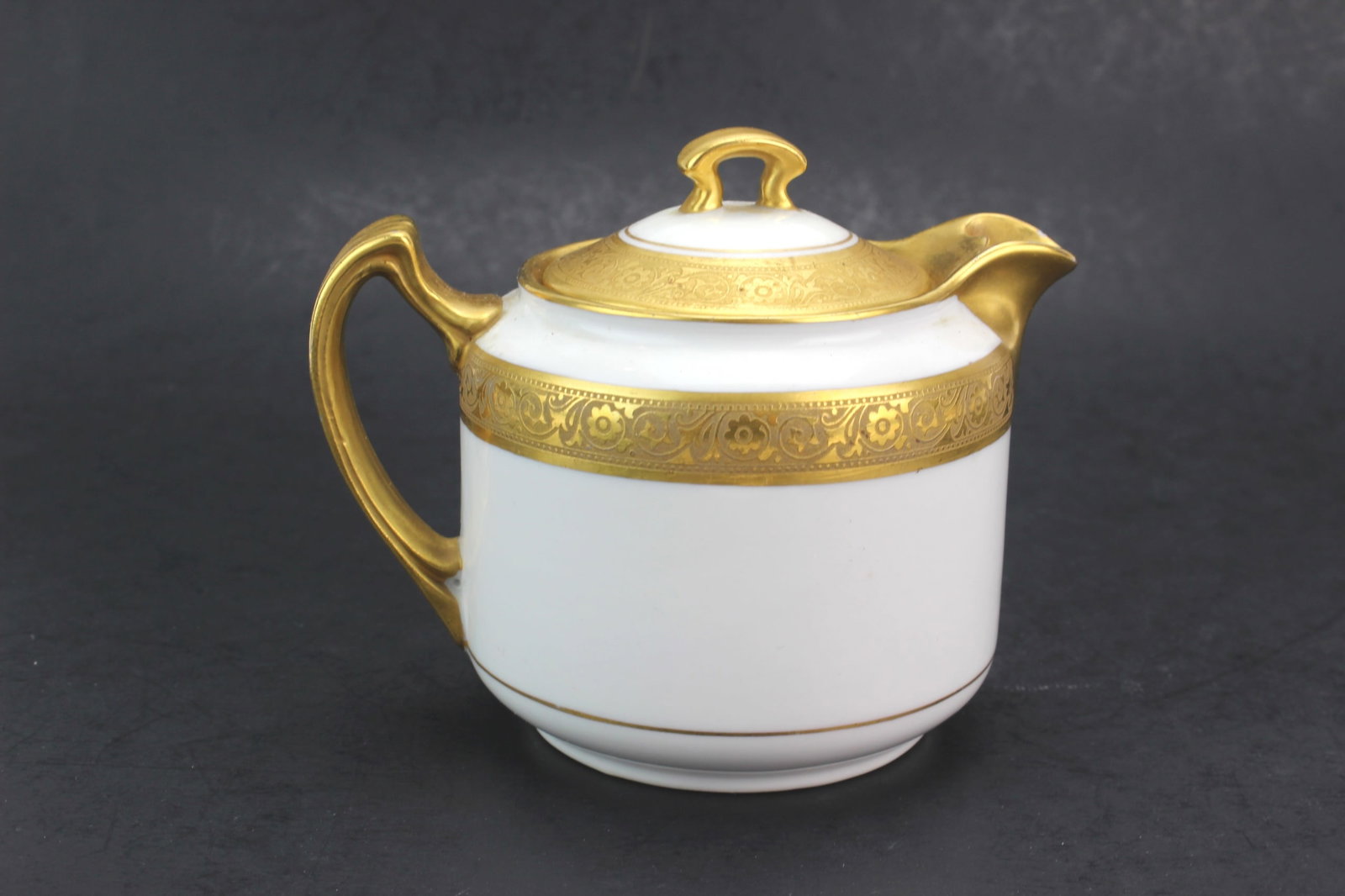 Pickard Etched China Teapot: Vintage Pickard china teapot featuring finely etched gilt floral decoration with gold-tone handle, spout, and lid accents. Measures 5 in. (L) X 4 in. (H) X 3 1/2 in. (W). Good overall condition with