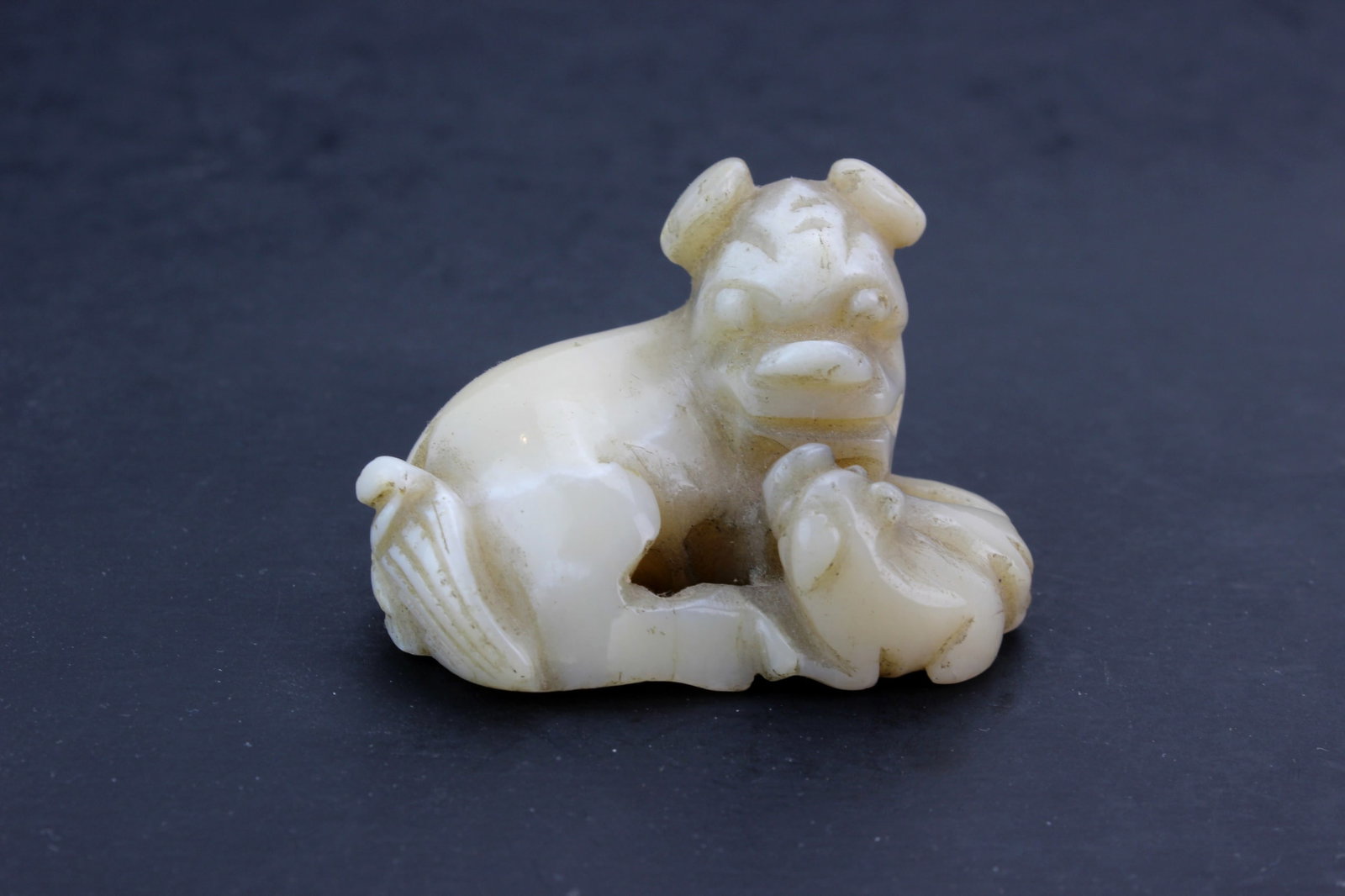 Chinese Hardstone Beast Figurine: Chinese carved hardstone mythical beast figurine with pierced carving details. Measures 2 X 1 1/2 X 1 1/2 in. Shows natural stone inclusions, light surface wear, and minor abrasions consistent with