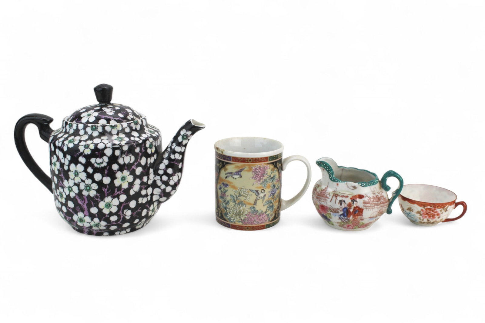 Lot of Four Japanese Porcelain Tea Wares: Lot of four Japanese porcelain tea wares, including a floral teapot, bird-and-flower mug, hand-painted creamer, and small floral cup. Various wear, stains, and cracks present. Largest 6 1/4 in. H, sma