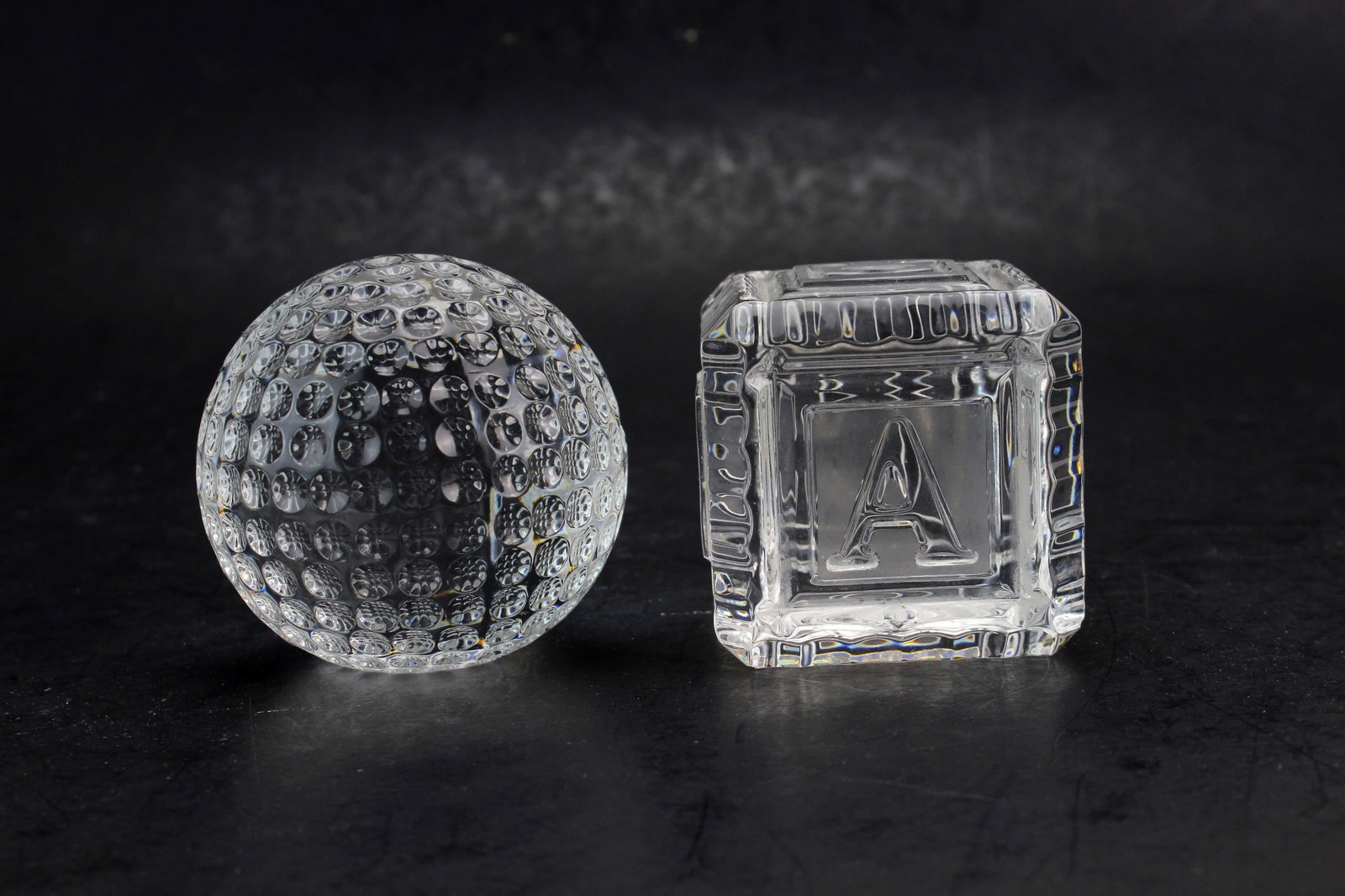 Waterford Crystal Ball & Alphabet Block: A pair of Waterford crystal decorative pieces, including a textured crystal ball and an alphabet square block. Ball measures approx. 2 1/2 in. (D); square block measures approx. 2 ? 2 ? 2 in. Clear