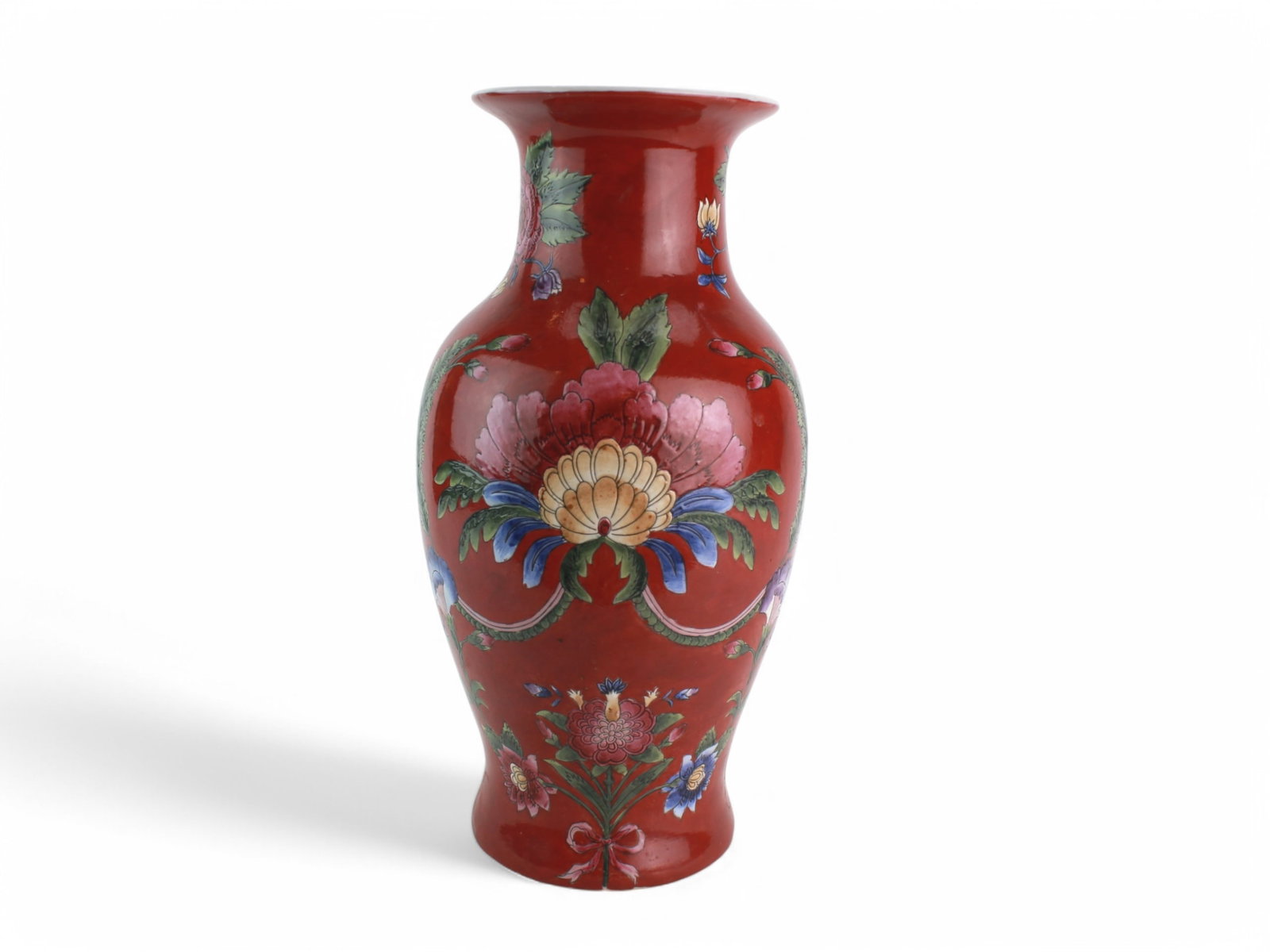 Chinese Red-Ground Famille Rose Floral Vase: A vividly colored Chinese porcelain vase with a rich red ground, decorated in famille rose enamels with blooming peonies, chrysanthemums, and scrolling leafy tendrils in pink, blue, yellow, and green 