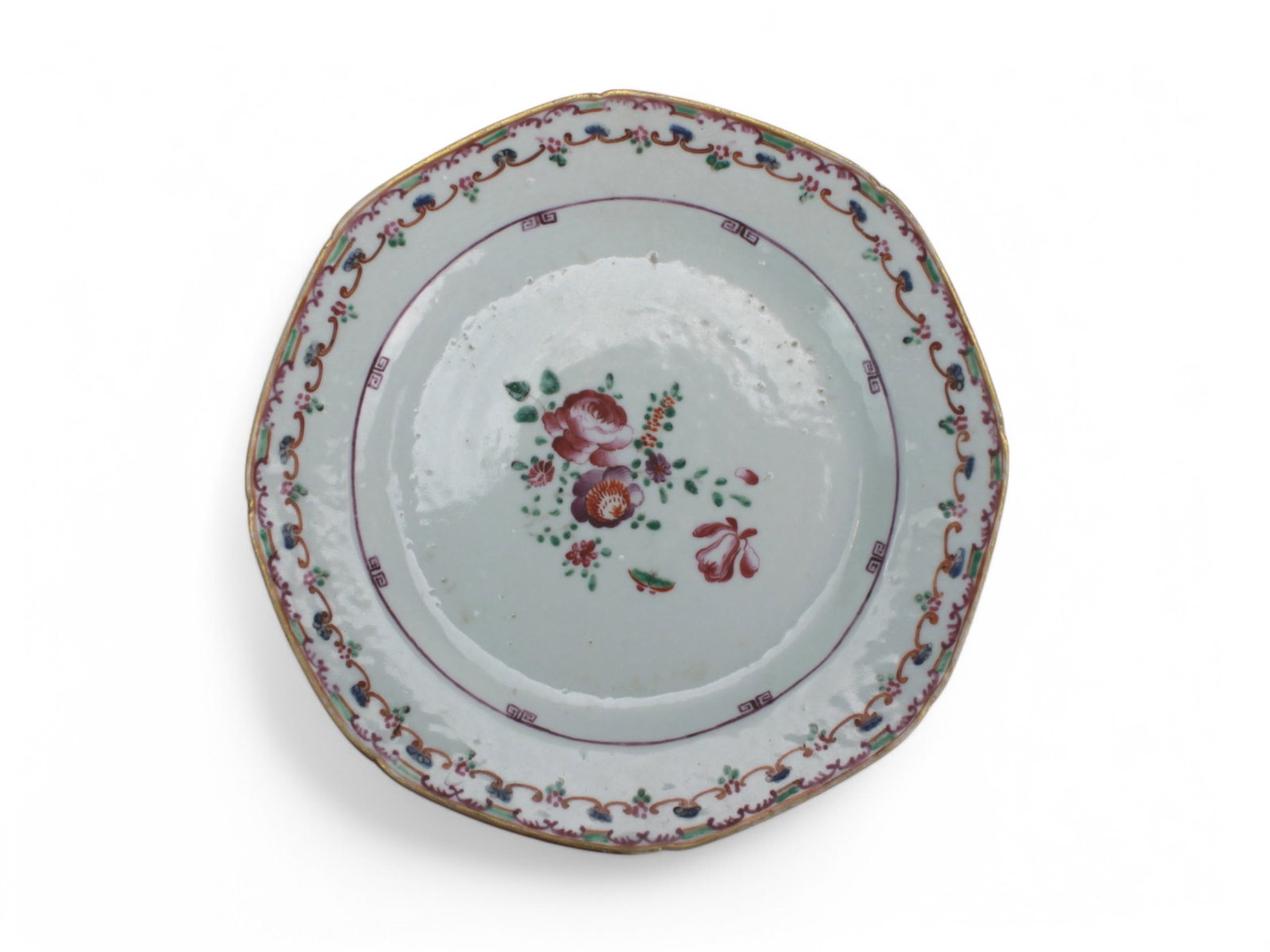 A Chinese Export Famille Rose Octagonal Plate: An octagonal Chinese Export porcelain plate, dating from the 18th century, features a delicate Famille Rose floral spray at its center, surrounded by a decorative border in iron-red, turquoise, and