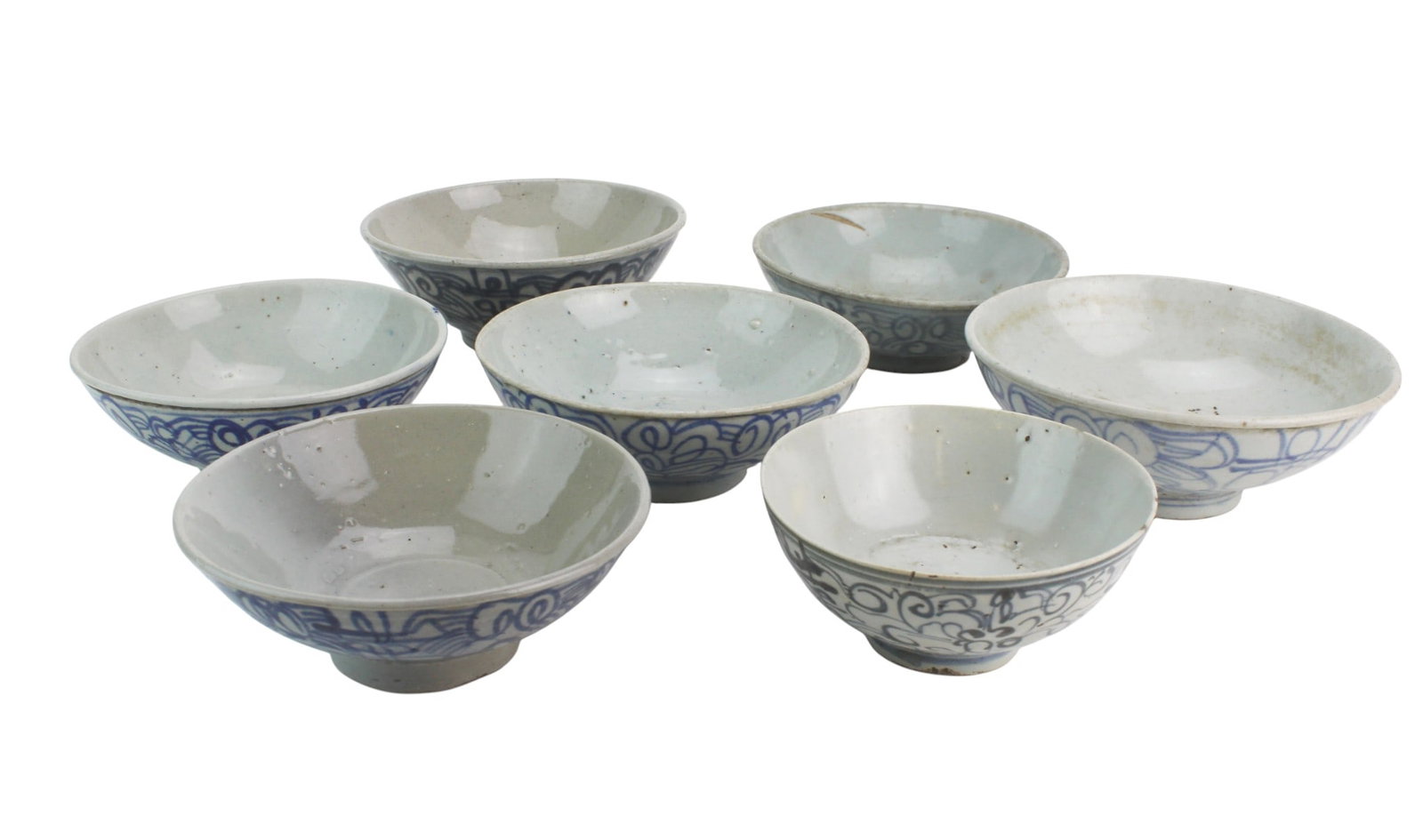 Seven Chinese Blue & White Porcelain Bowls: A lot of seven blue-and-white porcelain bowls with hand-painted scroll motifs. The largest bowl measures 6 1/4 in. (D) ? 2 1/2 in. (H). Surfaces show expected wear, glaze spots, firing flaws, rim