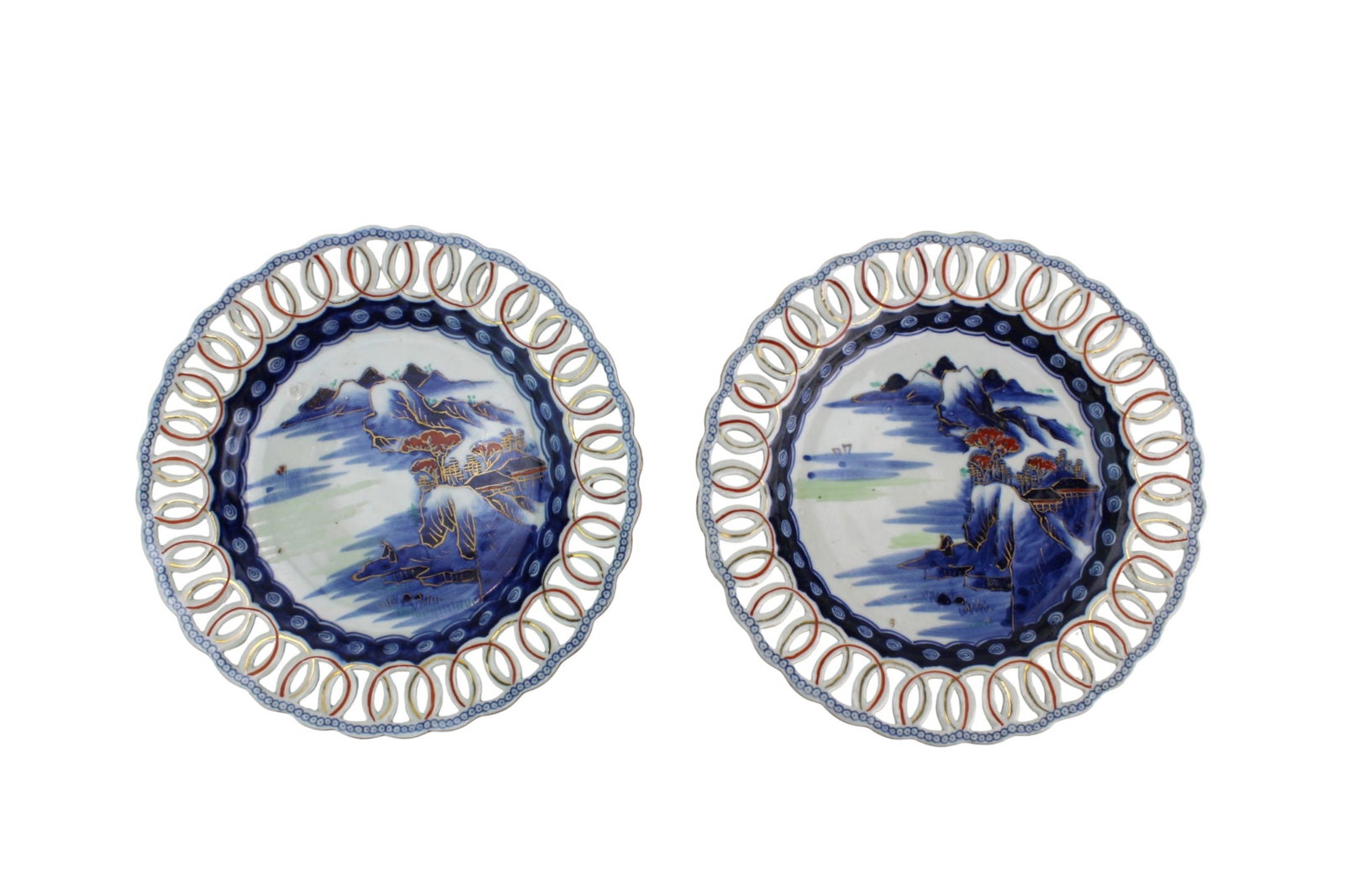 Pair Japanese Imari Reticulated Plates: Matching pair of Japanese Imari reticulated porcelain plates with pierced rims, iron-red and gilt decoration, and blue-and-white landscape centers. Each measures 1 1/4 in. (H) ? 8 3/4 in. (D).