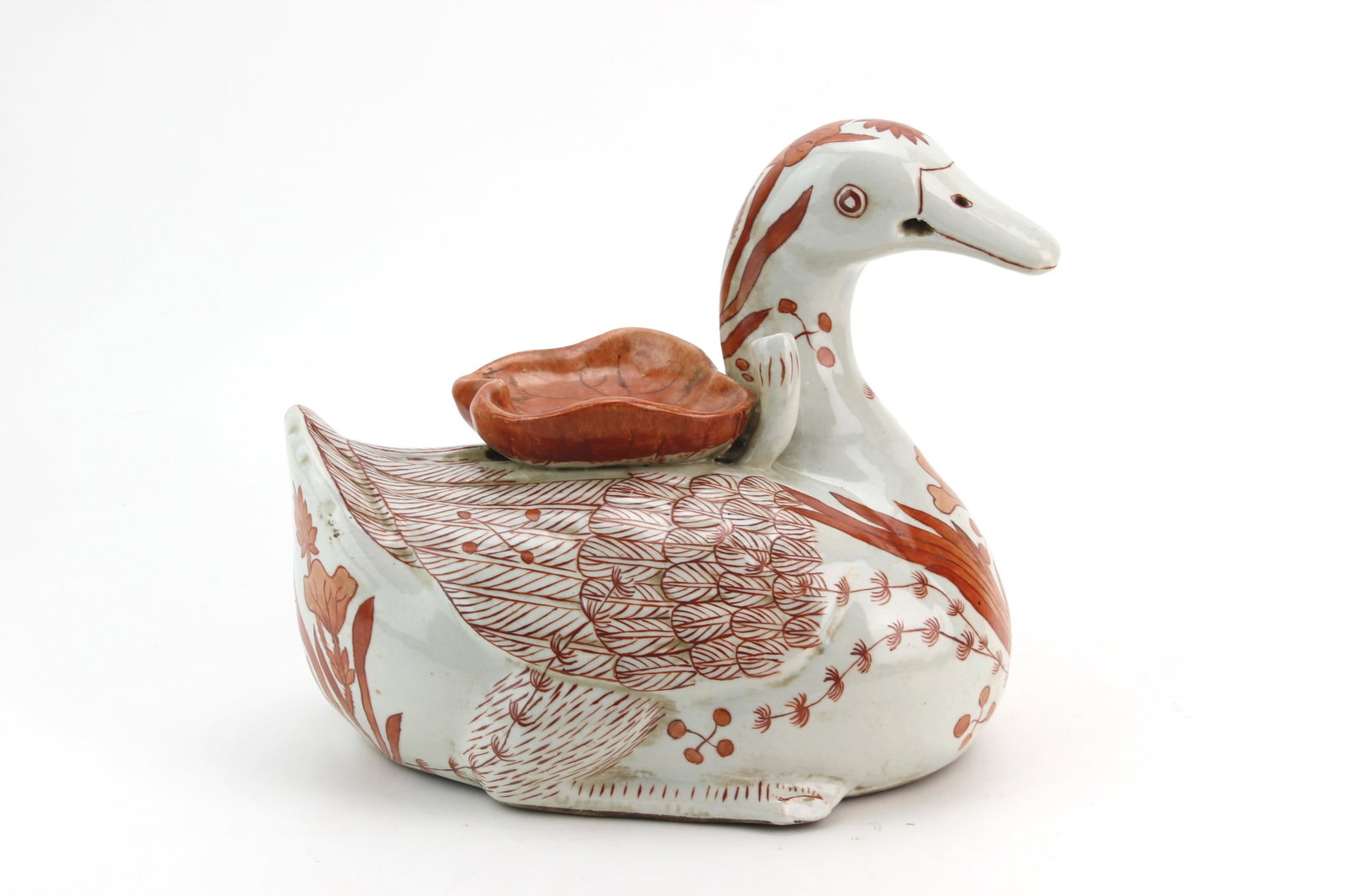 Chinese Red Decor Duck Figurine: Chinese ceramic duck-form figurine featuring iron-red floral and foliate decoration, with a small dish on its back. Approx. size: 7 1/2 in. (H) X 9 in. (L) X 6 in. (W).Condition: Shows visible wear co