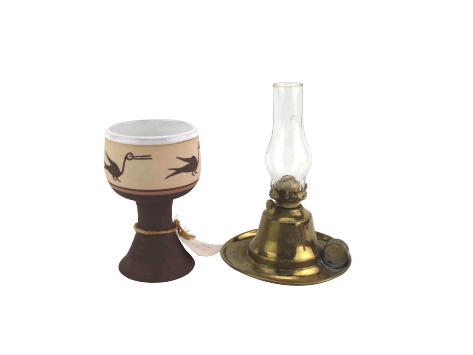 A Ceramic Goblet and Miniature Brass Oil Lamp: A handcrafted ceramic goblet in 4 1/2 in. tall with bird motifs made by girls from a Peruvian orphanage, paired with a small vintage brass oil lamp in 6 in. tall featuring a glass chimney and wick