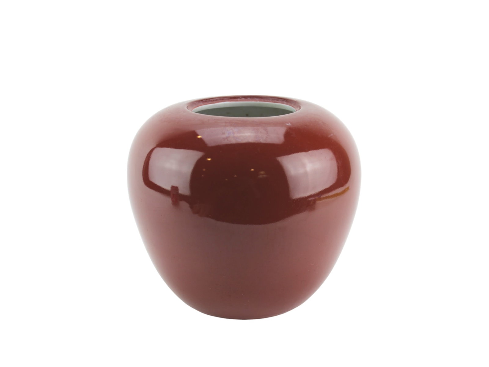 Chinese Oxblood-Glazed Porcelain Ginger Jar: A vintage Chinese porcelain vase with a rich oxblood (sang-de-boeuf) glaze. The vase has a rounded body with a short neck and unglazed foot rim, revealing the pale ceramic body beneath. Size: 6 1/4 in