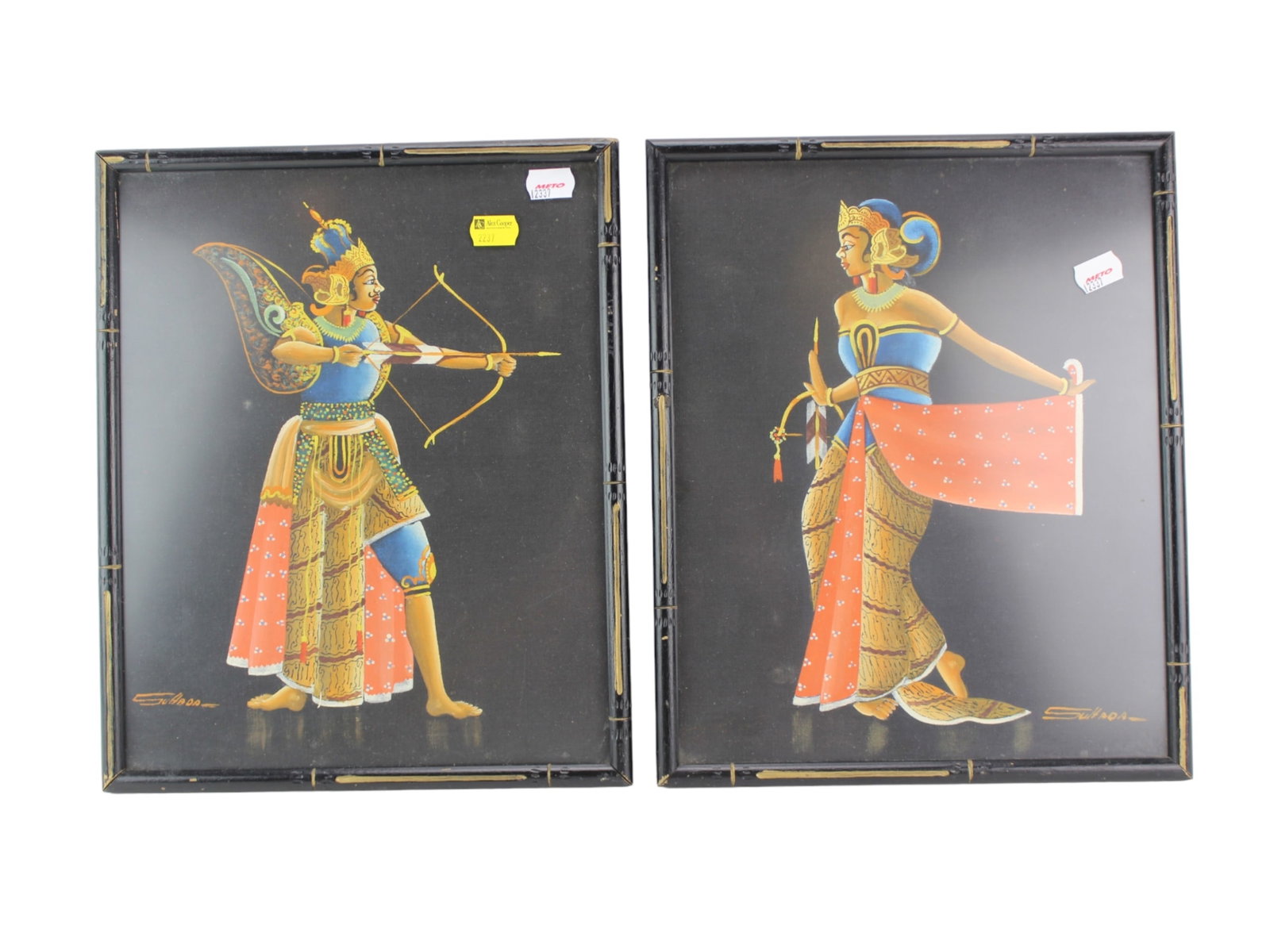 Pair of Acrylic Paintings of South Asian Figurines: Pair of Balinese-style paintings by Suhoda, depicting a warrior and a dancer in traditional attire, set against black backgrounds and framed in bamboo-style frames. Dimensions is 11 X 13 1/2 in. each.