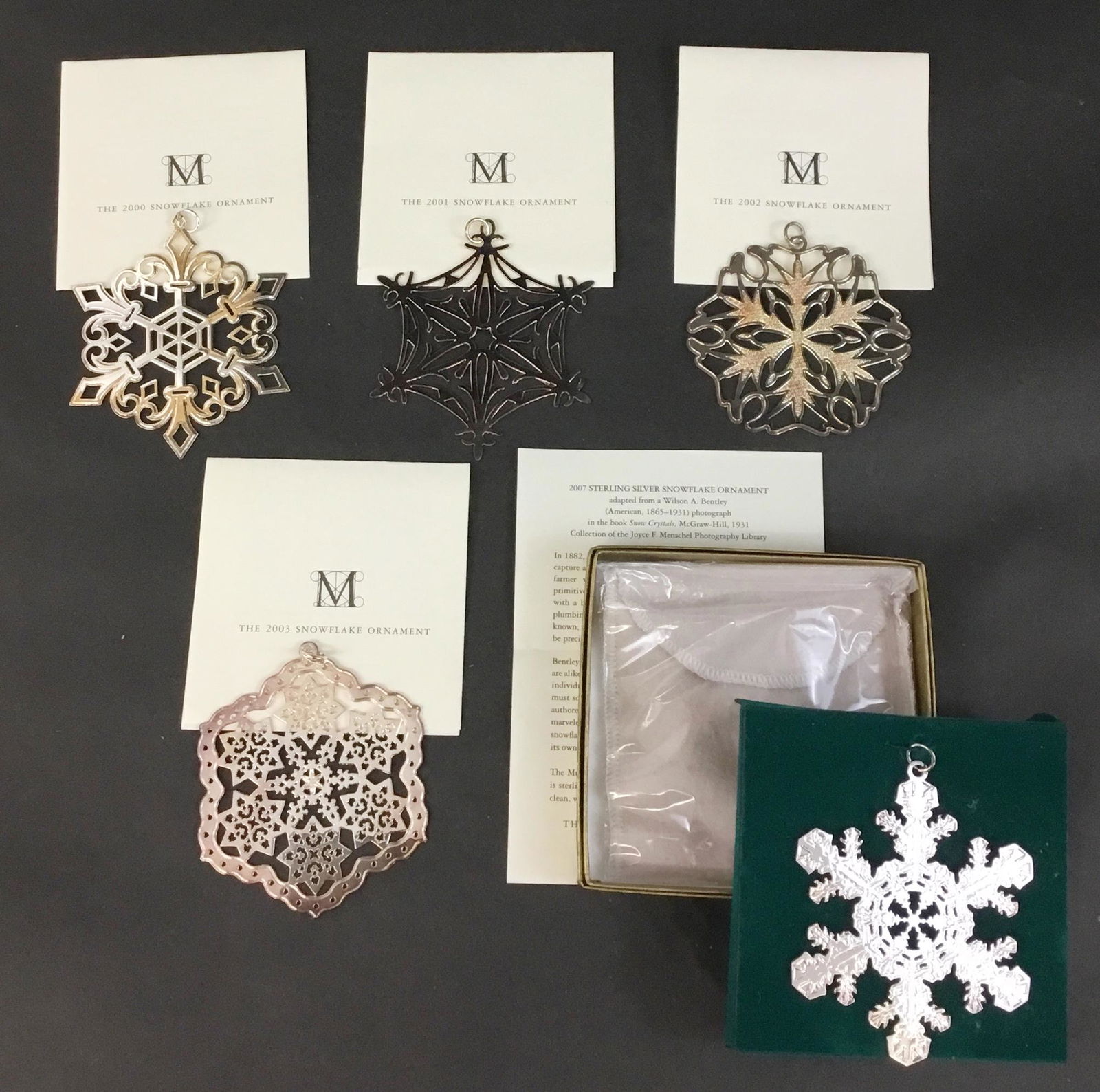Lot of 5 MMA Snowflake Sterling Silver Ornaments 2000's: Lot of 5 MMA Sterling silver snowflake Christmas ornaments from the 2000's. There is 2000, 2001, 2002, 2003, & 2007. (See other lot for 04 - 06) Each has original box, pouch, and paperwork. '07 is sti