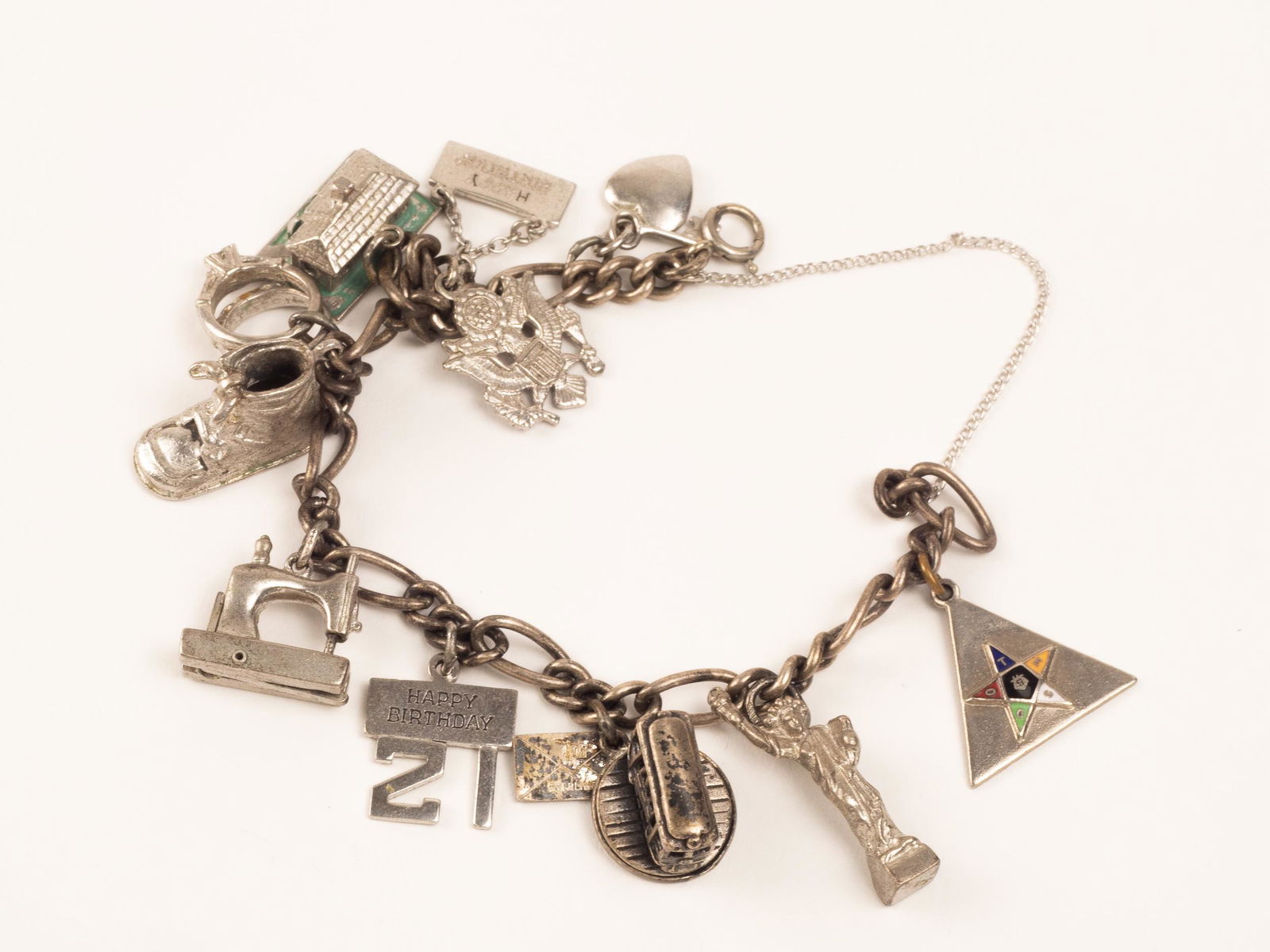Sterling Silver Charm Bracelet and Charms: Vintage sterling silver bracelet and charms, including Eastern Star, sewing machine, wedding rings and more.