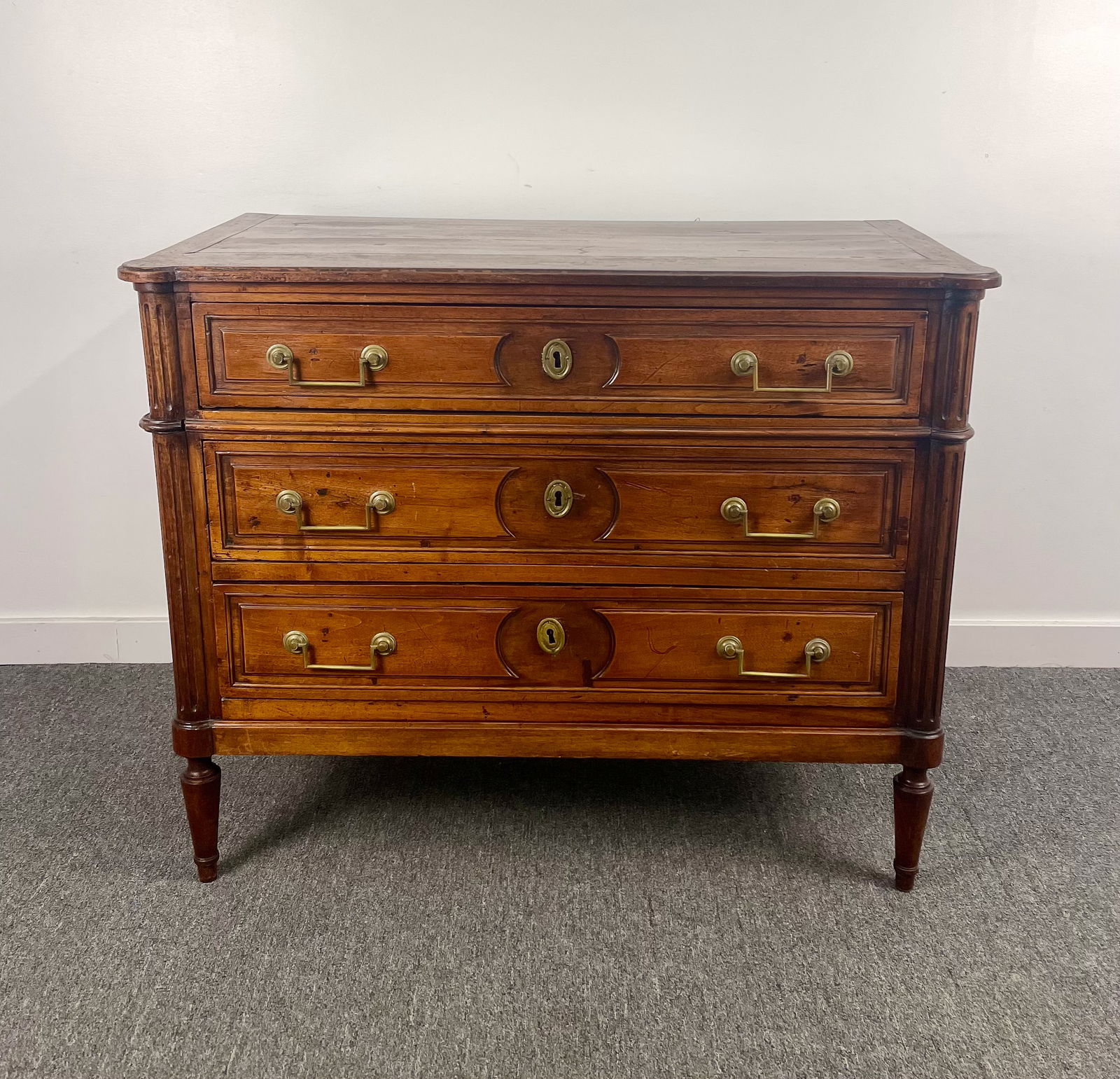 Period Louis XVI Three Drawer Commode: Terrific early and authentic piece. Handsome form and proportions, with fluted corners. The back attests to its age. Brasses are all present and original, but one needs a bit of attention. Small holes