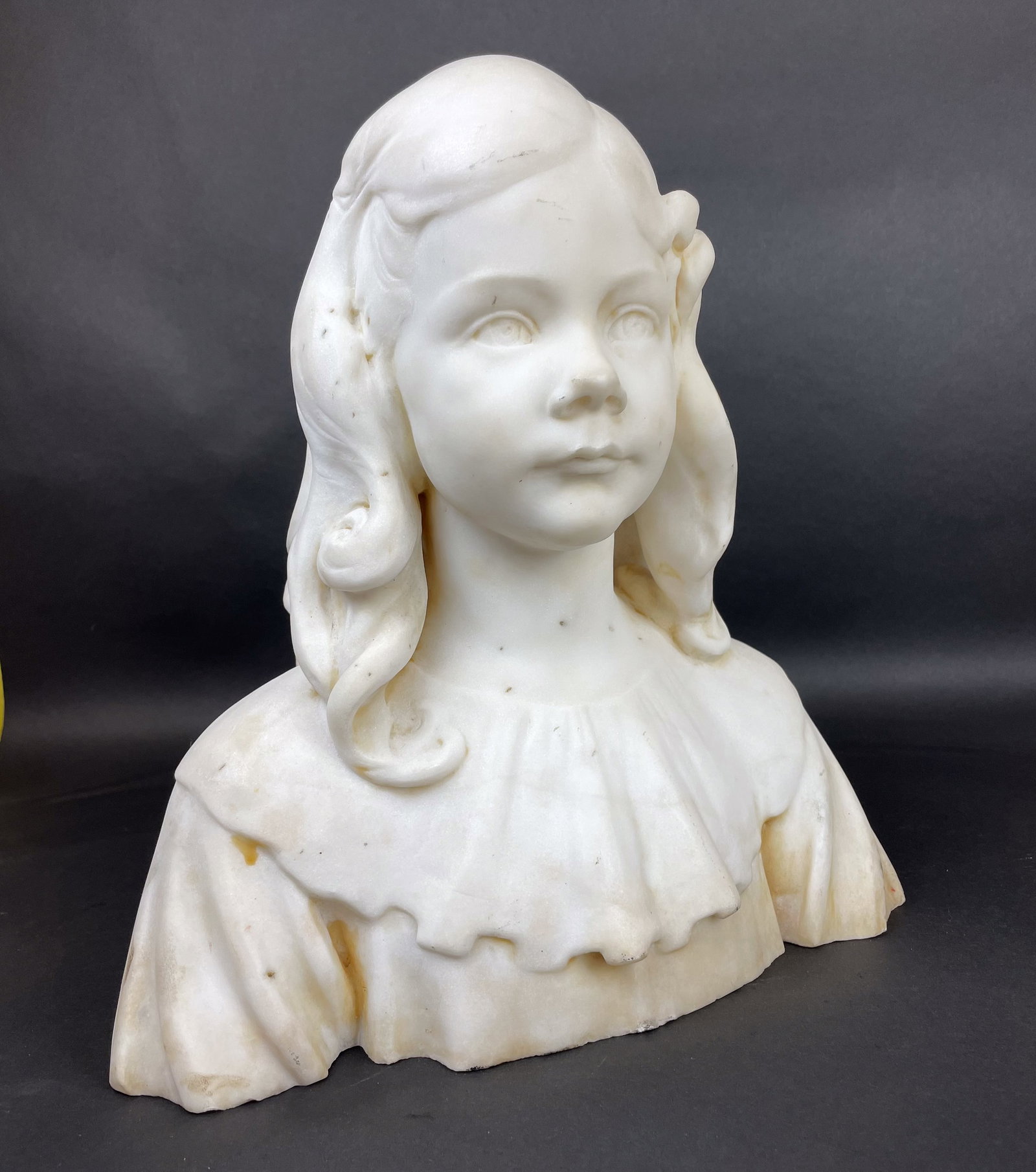 Beautifully Carved Alabaster Bust of Girl: Lovely carving in alabaster of a girl with a lace collar and hair down on her shoulders. Some discoloration. Very well executed. 14.5"w x 10"d x 15"h