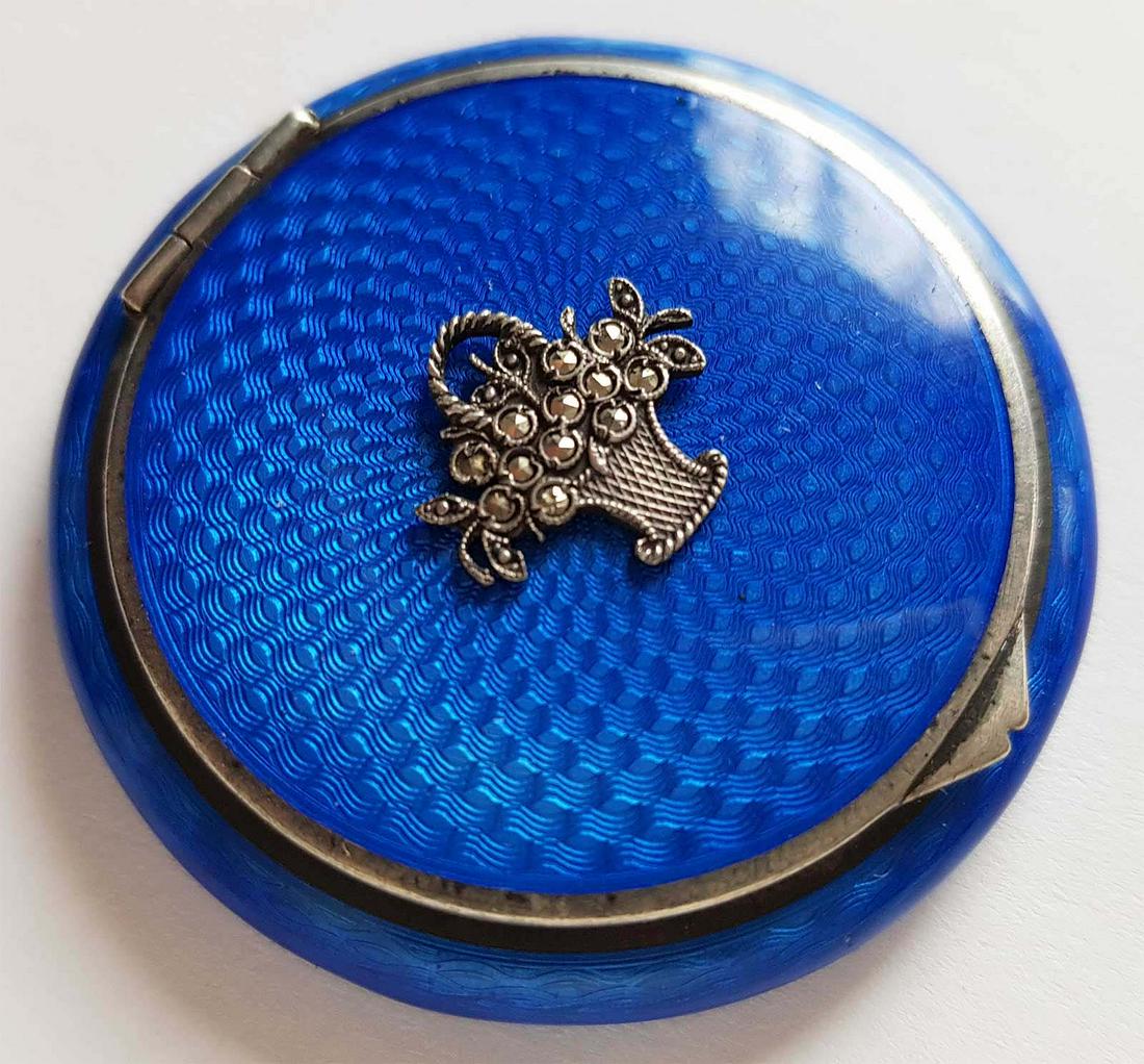 RUSSIAN SILVER ENAMEL COMPACT BOX, FABERGE STYLE: RARE CONTINENTAL SILVER and ENAMEL COMPACT BOX, FAMOUS STYLECompact in blue guilloche enamel. The lid decorated with a silver and marcasite basket offlowers. Marked. Early 20th C. SIZE: Dia. 4.4 c