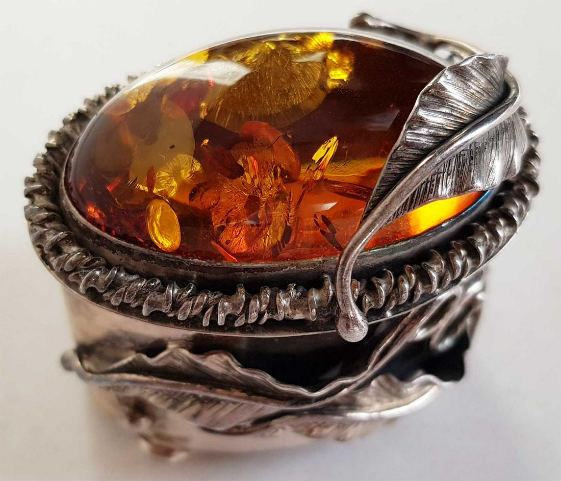 ANTIQUE AMBER & SILVER JEWELRY BOX: ANTIQUE AMBER and SILVER JEWELRY BOX Amber cabochon, silver hinged box. Marked. Very nice item. SIZE: 41 x 47 mm, gross weight 55.96 grams. ESTIMATE PRICE: $300 - $400. HISTOR