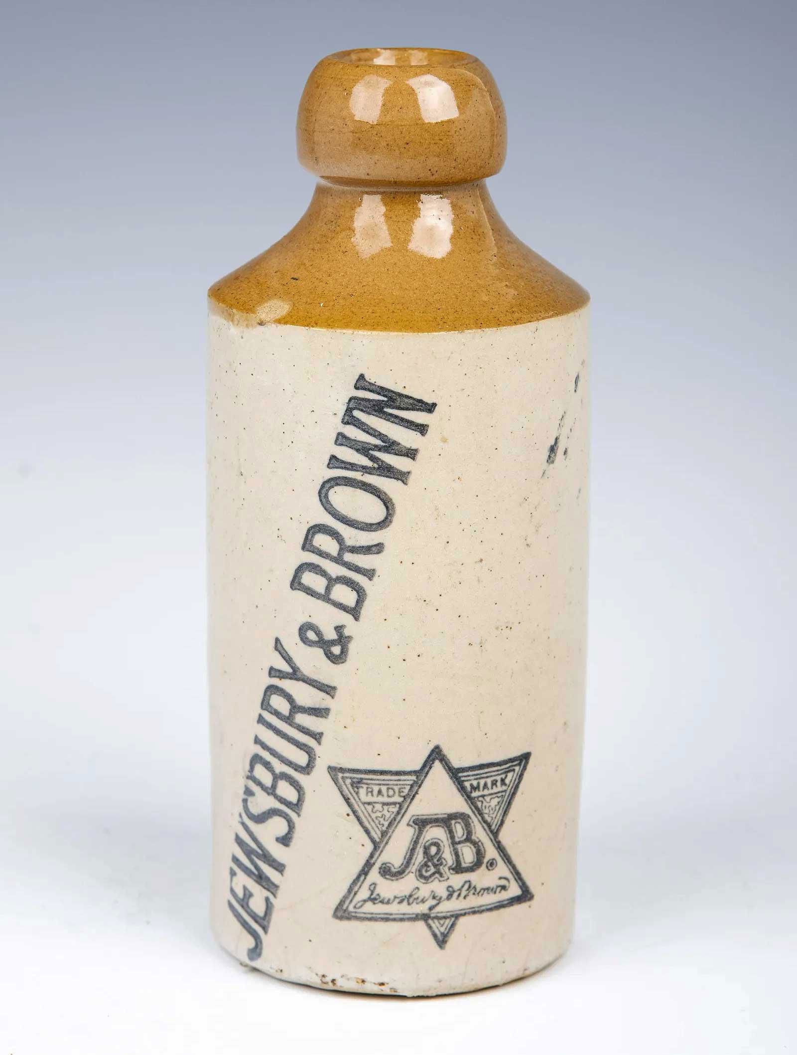 CERAMIC LIQUOR BOTTLE FOR JEWSBURY with DAVID STAR: JEWISH CERAMIC LIQUOR BOTTLE FOR JEWSBURY & BROWN with STAR of DAVID American, circa early 20th century. Imprinted with a Jewish star of David. Brown in color. Marked. CONDITION: Overall condition is