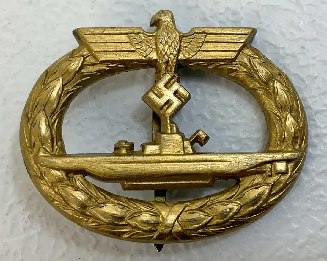 GERMAN WW2 KRIEGSMARINE U-BOAT BADGE: GERMAN WW2 NAVY KRIEGSMARINE U-BOAT WAR BADGE Produced in 1942-1945. Zinc, gilded. Solid swastika, sngle hing, wide coke bottle-shaped pin, flat catch with round base plate. Textbook example. HALLMARK