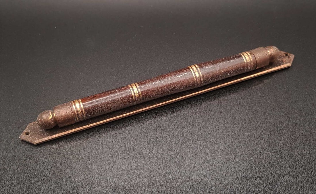 JEWISH ANTIQUE MEZUZAH w. ROLLED PARCHMENT: JEWISH ANTIQUE MEZUZAH with ROLLED PARCHMENT A Mezuzah case designed in the classical style with a cylinder. Contained within the Mezuzah is a tightly rolled piece of parchment made from the skin of a