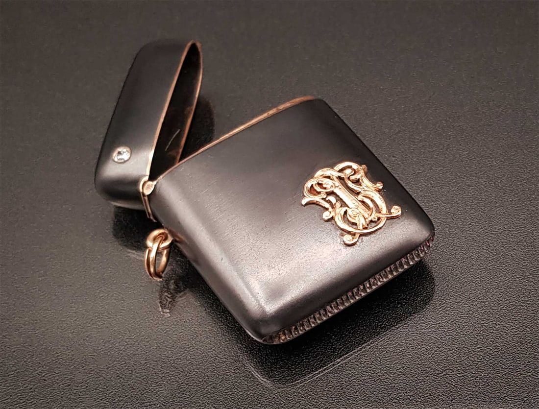 GOLD, DIAMOND & RUBY MATCH HOLDER: GOLD, DIAMOND, RUBY and GUN METAL MATCH HOLDER, 19th CENTURY Russian gunmetal and gold match holder. The case features a hinge, a lock with a ruby stone, and gold monogram initials. It also boasts a l