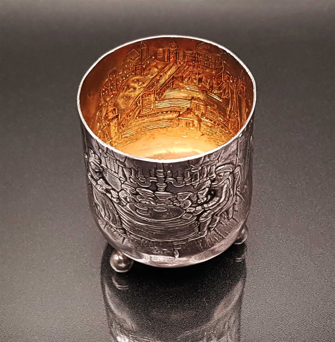 JEWISH RUSSIAN SILVER KIDDUSH BEAKER: RARE ANTIQUE JEWISH RUSSIAN SILVER KIDDUSH BEAKER This is an antique Jewish kiddush beaker made in Russia, featuring reliefs of the Temple and a family sitting at the Passover Seder table. It stands o