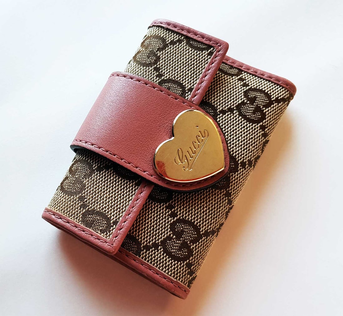GUCCI LOGO MONOGRAM KEY CASE HOLDER, 203551- 2778: AUTHENTIC GUCCI LOGO MONOGRAM and METAL HEART KEY CASE HOLDER WALLET, 203551- 2778 This key case features brown monogram canvas and pink leather. Closes with a heart shaped gold-tone button snap, insi