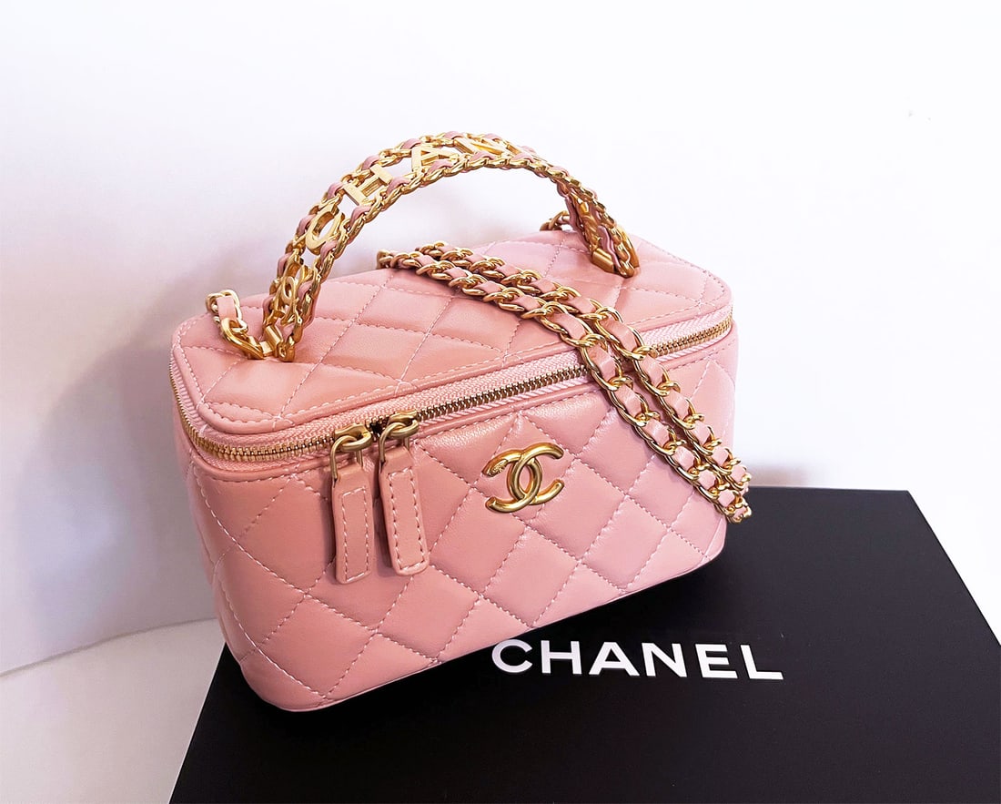CHANEL SMALL CHARMING HANDLE VANITY CASE: CHANEL CLASSIC TOP HANDLE VANITY CASE with CHAIN QUILTED LAMBSKIN SMALL This Chanel Top Handle Vanity Case with Chain is in pink lambskin leather with light gold tone hardware, featuring signature dia
