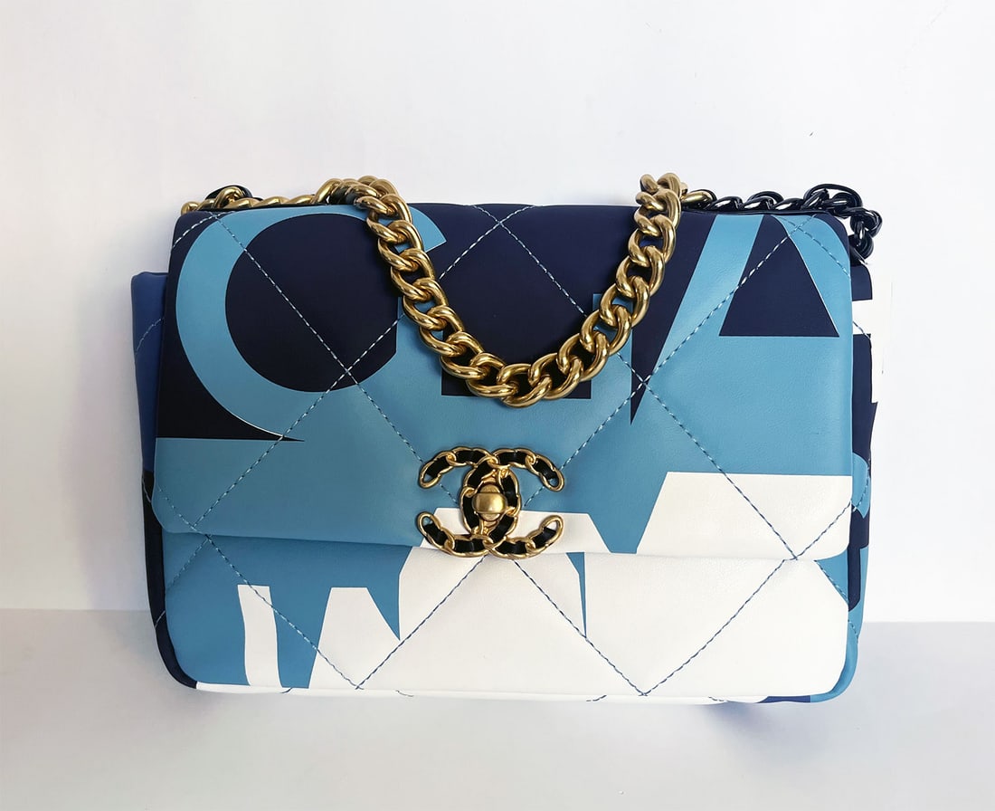 CHANEL 19 CLOTH HANDBAG MULTICOLOR: CHANEL 19 FLAP BAG with "CHANEL" MULTICOLOR PRINTED SILK Multicolor "CHANEL" printed silk inspired by Paris skyline. Bag highly sought after. Mixed metal hardware Gold-Tone, silver-tone & ruthenium-fi