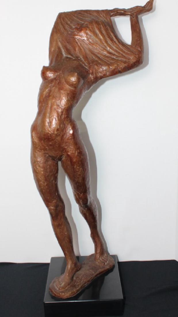 Artist: Glickman, Arthur (Am. 1923-2011): Untitled. Dimensions: 30H, base 9.5 x 3 in. Medium and support: Bronze with brown patina. Signature: On base A. Glickman. Circa: Dated 1979Description: Figure of a woman trying to remove a shirt over
