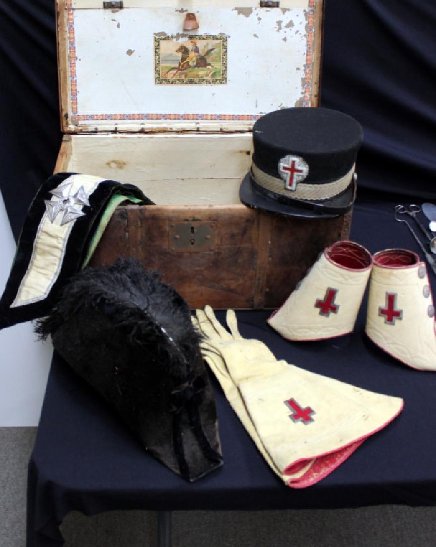 Knights Templar Regalia: Wooden box holds black hat with feather, hat with cross emblem on front, gloves, cuffs and sash.