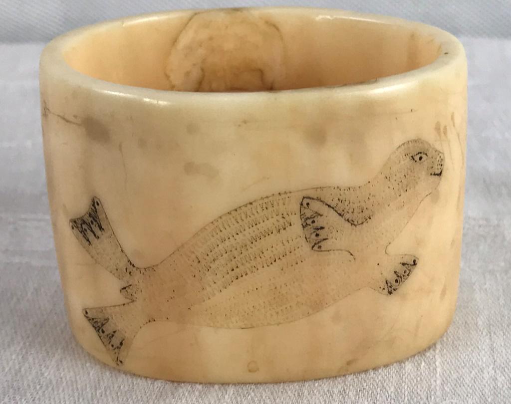 Walrus Tusk Skrimshaw Napkin Ring 2nd Gold Rush: Scrimshaw decorated on two sides with walrus. 1.75h x 2.5w x 7/8d inches. 2.2 oz