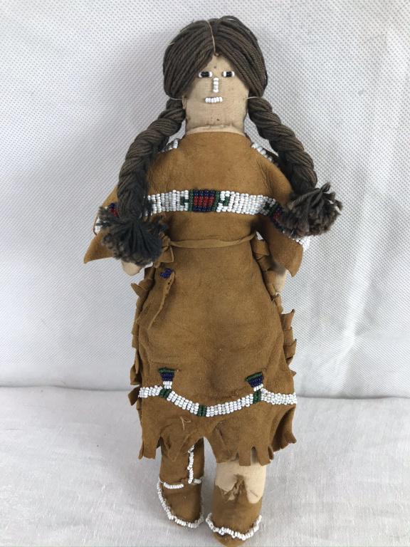 Plains Indian Doll in Leather Dress w/Beadwork: Yarn hair, leather dres with beadwork, leather moccasins sew on to legs with beads. Part of leather moccasin missing. 9.5h x 4w inches.