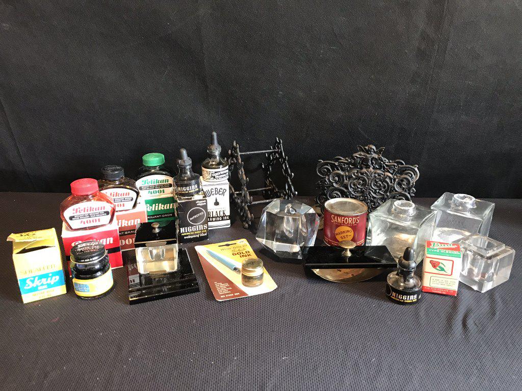 Inkwells, Ink & Accessories: 3 Bottles of black + Green, Brown, Red Ink. Liquid gold (apears good). 5 glass ink wells. Cast metal pen holder, Cast metal letter holder, dried bottle Higgins Black Ink. Sanfords Bottle (Dry). Blotte