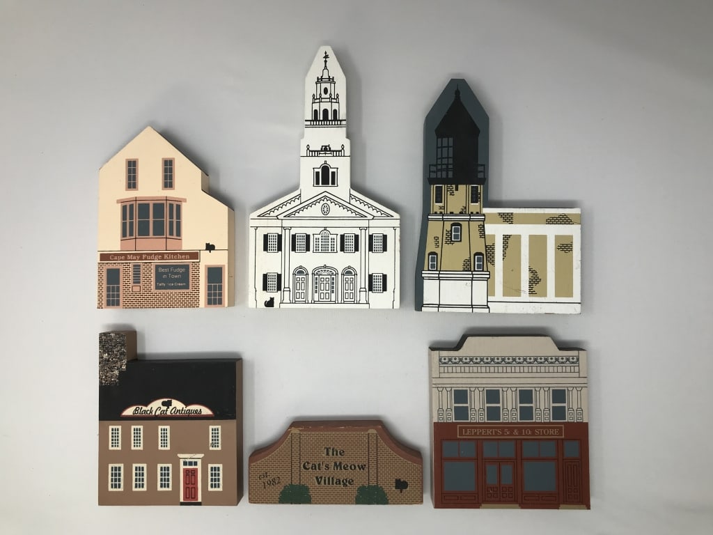 The Cat's Meow Village & Hometowne Collection: The Cat's Meow Village & Hometowne Collection. 6 Pieces. Black Cat Antiques, Leppert's 5 & 10 Store, Cape May Fudge Kitchen, United Church of Acworth, Split Rock Lighthouse. 4"h - 5"h. 1 lb. 9 oz.