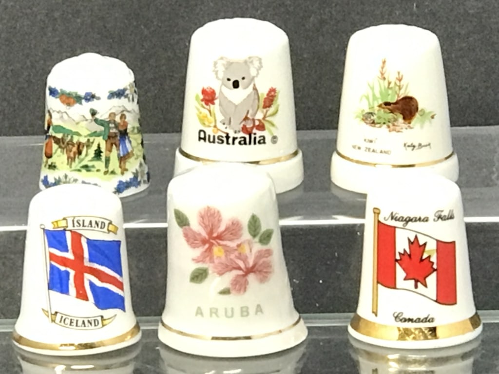 Thimbles from International Countries (6): Thimbles from Various Countries, 6 total. Canada, Iceland, New Zealand, Aruba, Australia and Austria. 1" - 1.25"h. 2.2 oz.