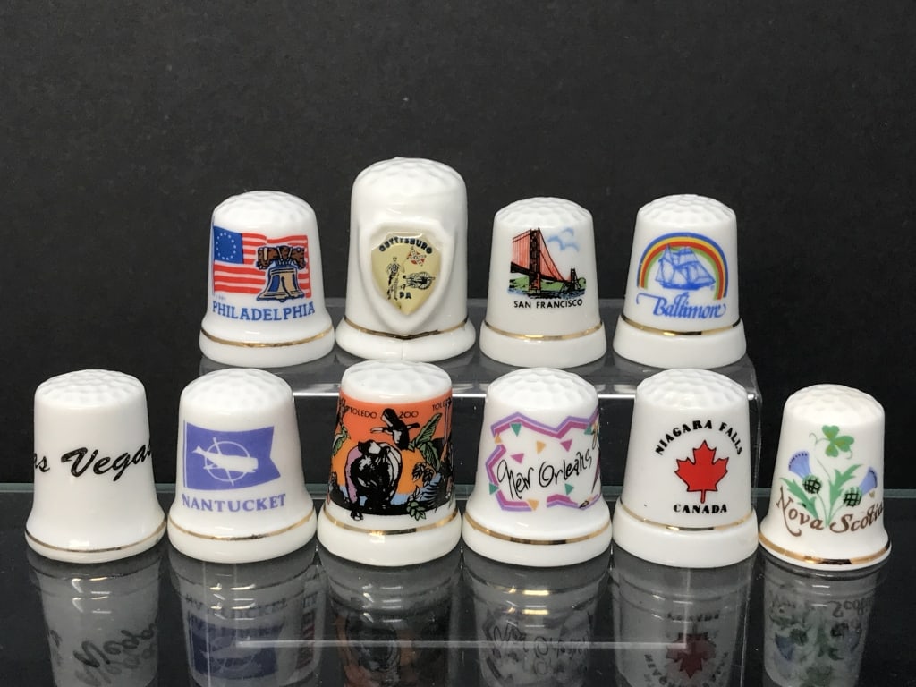 Thimbles Representing U.S. Cities (10): Thimbles, Cities and Providence, 11 total. San Francisco, Baltimore, New Orleans, Philadelphia, Toledo, Nantucket, Cape May, Gettysburg, Las Vegas, Niagara Falls, Nova Scotia. 1 1/6" - 1 7/16"h. 3.4 o