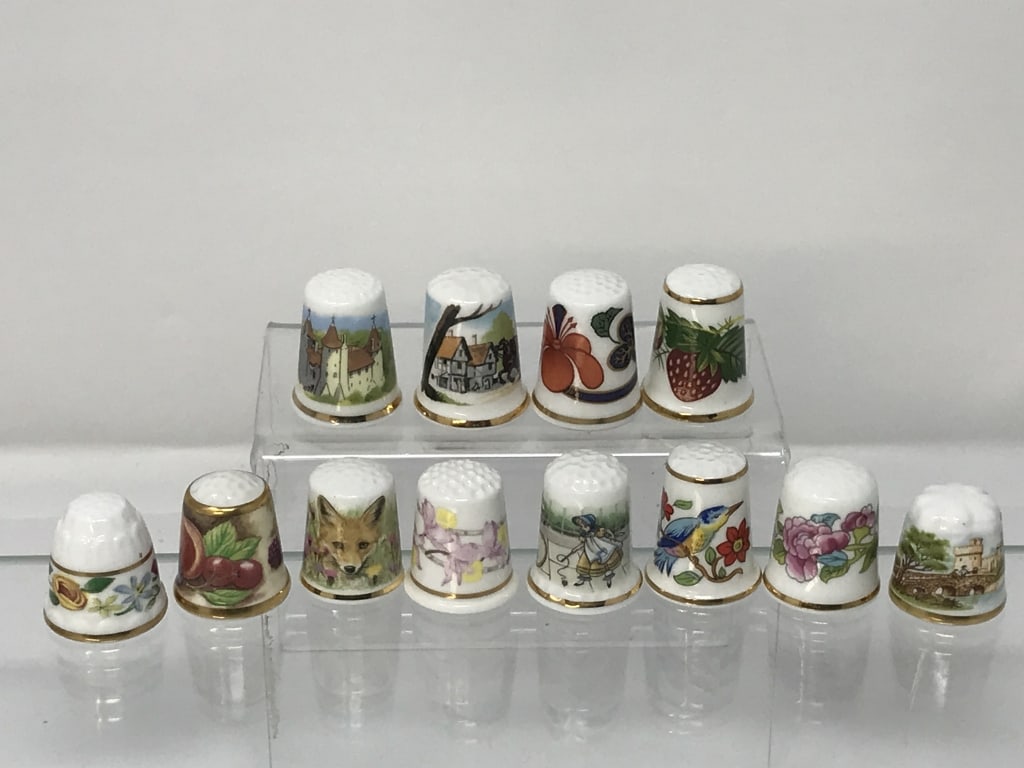 Porcelain Thimbles Made in England (12): Porcelain Thimbles made in England, 12. Oakley, Longton Hall, Ansley, Royal England, Avonvale, Vale, Rockingham, Hummersley, Royal Worcester, Royal Coach, Walls Pottery. 7/8" - 1 1/8"h. 2.5 oz.
