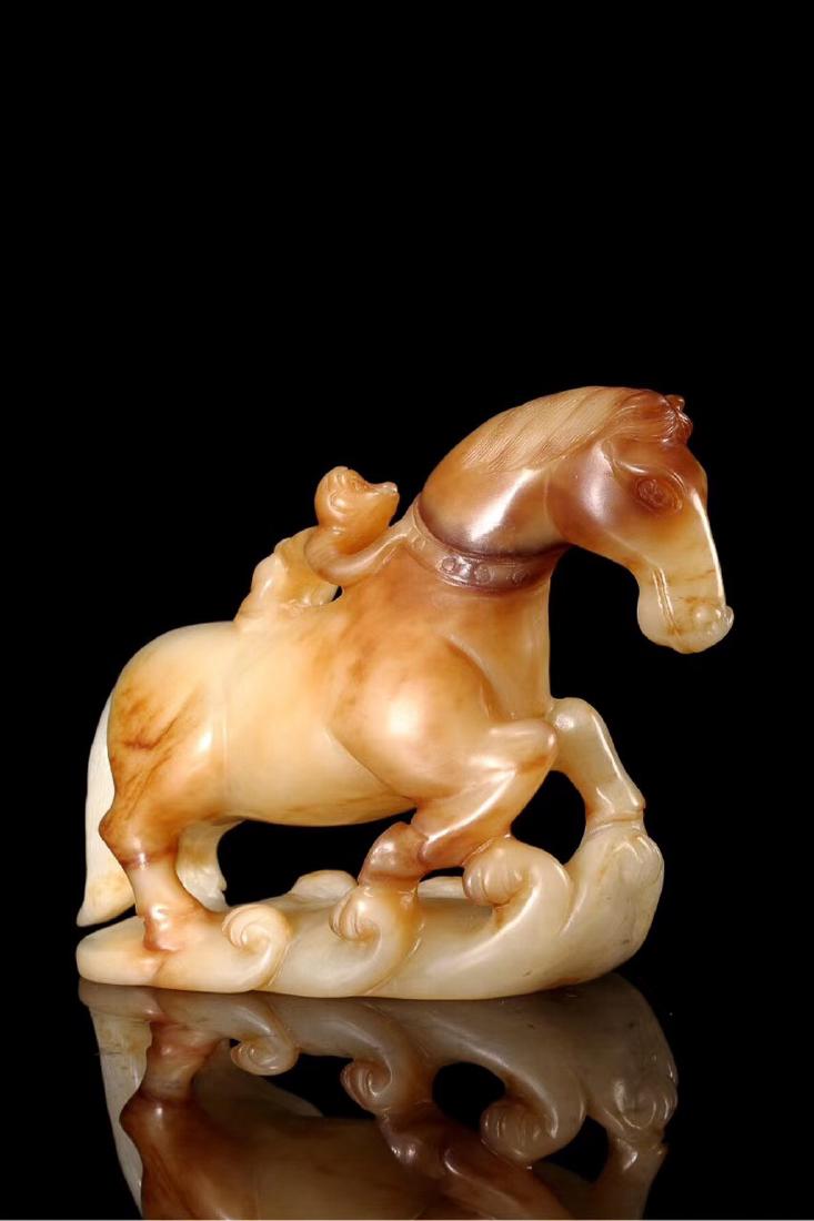 A HETIAN JADE "MA SHANG FENG HOU" ORNAMENT: A monkey is riding on the back of horse. All Commodities phase. Dimension length 11.5cmï¼› height 10 cm; weight 500 g