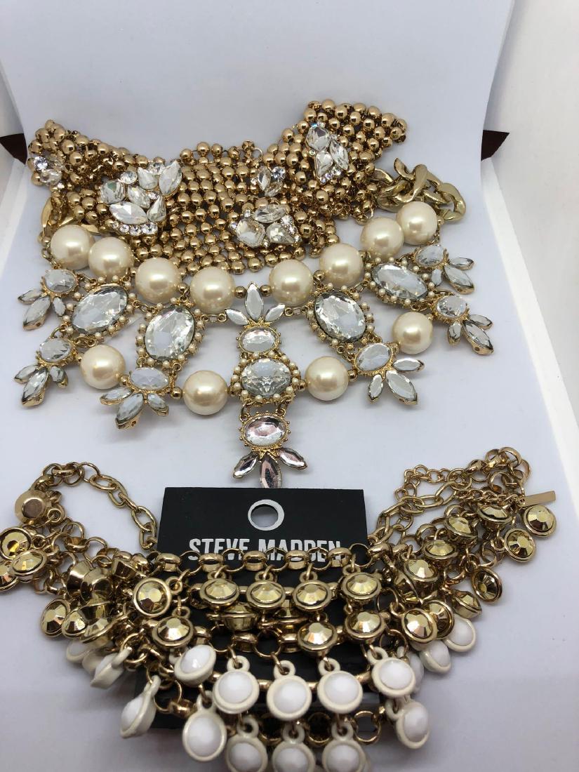 3 Statement Necklaces including Steve Madden: 3 Statement Necklaces, including Steve Madden, on Gold-Tones and Shades of White. Steve Madden Necklace Length: 9.5in when closed. Faux Pearl Necklace Length: 9.25in when closed. Bib Necklace Length: