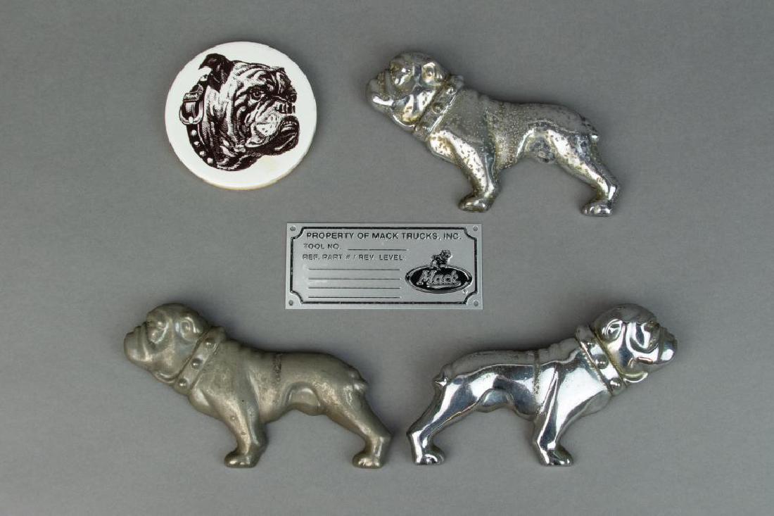 Lot Five (5) Mack Truck Collectables: Lot Five (5) Mack Truck collectables. Includes: One (1) Mack Truck bulldogs coaster. Condition: Cork on back is chipped off. Three (3) Bulldog plated emblems. Condition: Fair. Rust and pitted. One (1)