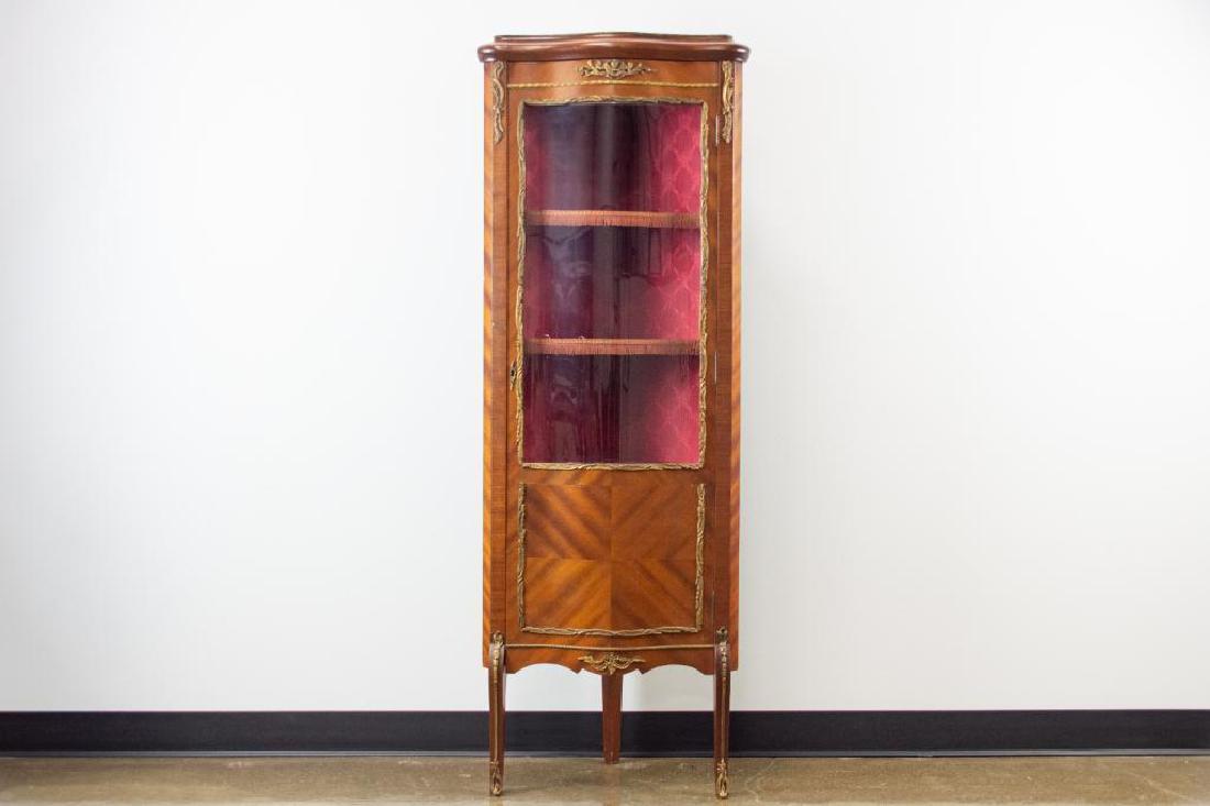 Victorian Corner Display Cabinet: Victorian Corner Display Cabinet. Beautiful brass details. Interior is lined with red silk fabric and tassel trim. Plexiglass door with brass trim border. Three cabriole legs. 21"Width; 14"Depth; 60"H