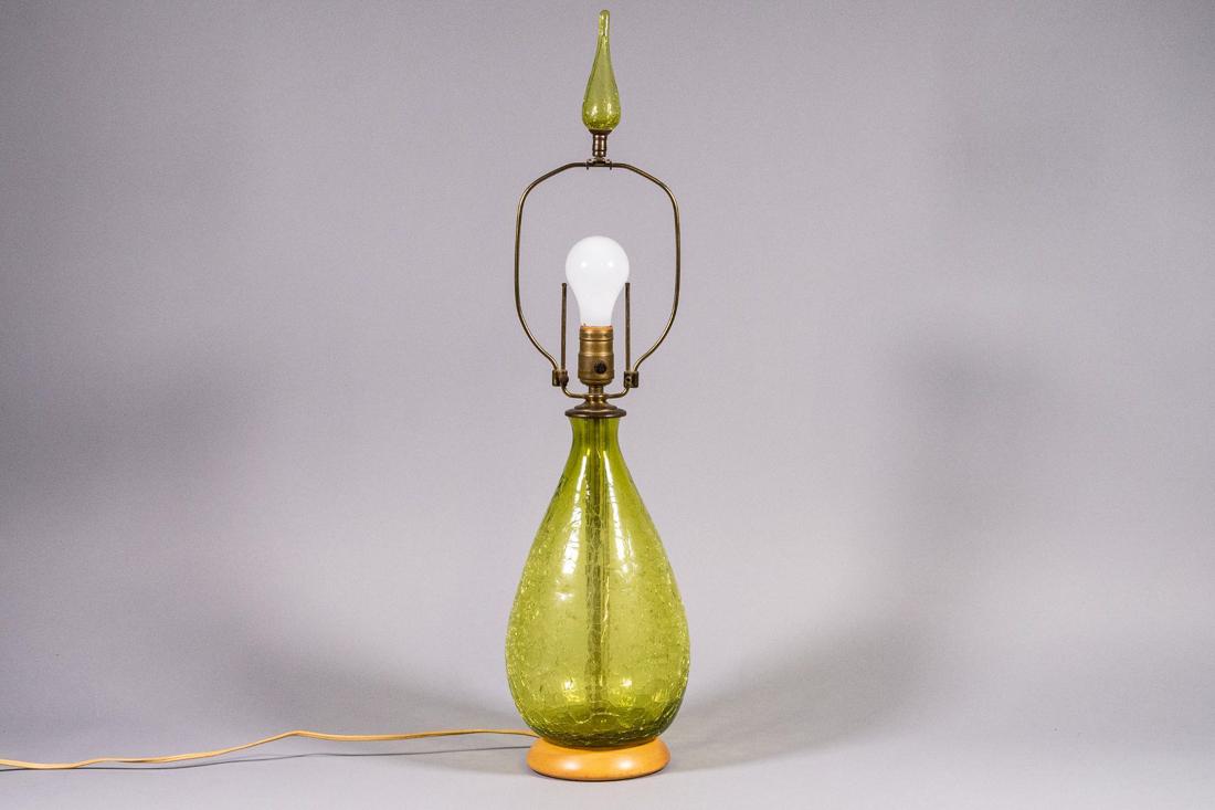 Blenko Blown Crackle Glass Lamp with Glass Finial: Beautiful shade of green blown crackle glass Blenko lamp with blown glass finial and wooden base. Original brass hardware. CREATOR: Blenko Glass (Designer). OF THE PERIOD: Mid-Century Modern. PLA