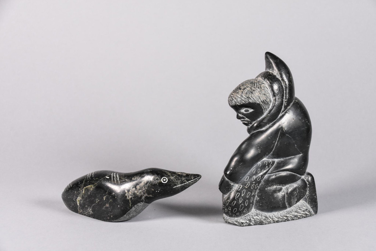 Two (2) Inuit Soapstone Sculptures: Two (2) Inuit soapstone sculptures. Includes: One (1) Inuit hunter sculpture, numbered and dated on the bottom, Â© 74 CONDITION: Good. MEASUREMENTS: H 5.5" x W 3.5". One (1) sculpture of a bird, num
